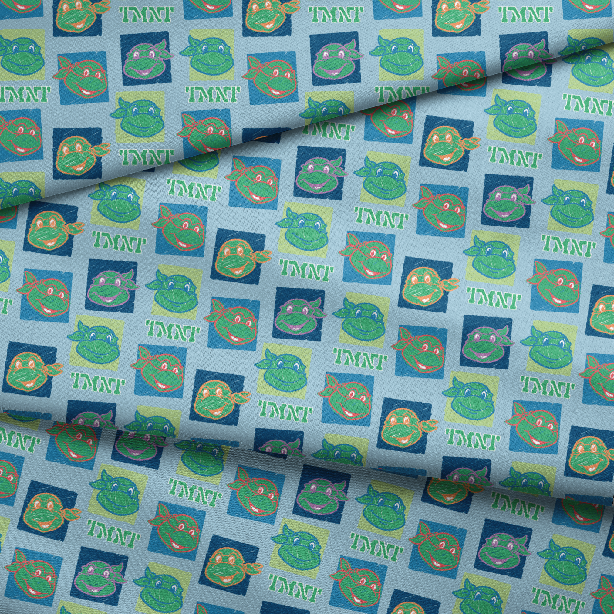 Teenage Mutant Ninja Turtles pattern with cartoon turtle faces in squares on light blue background fabric fold mockup
