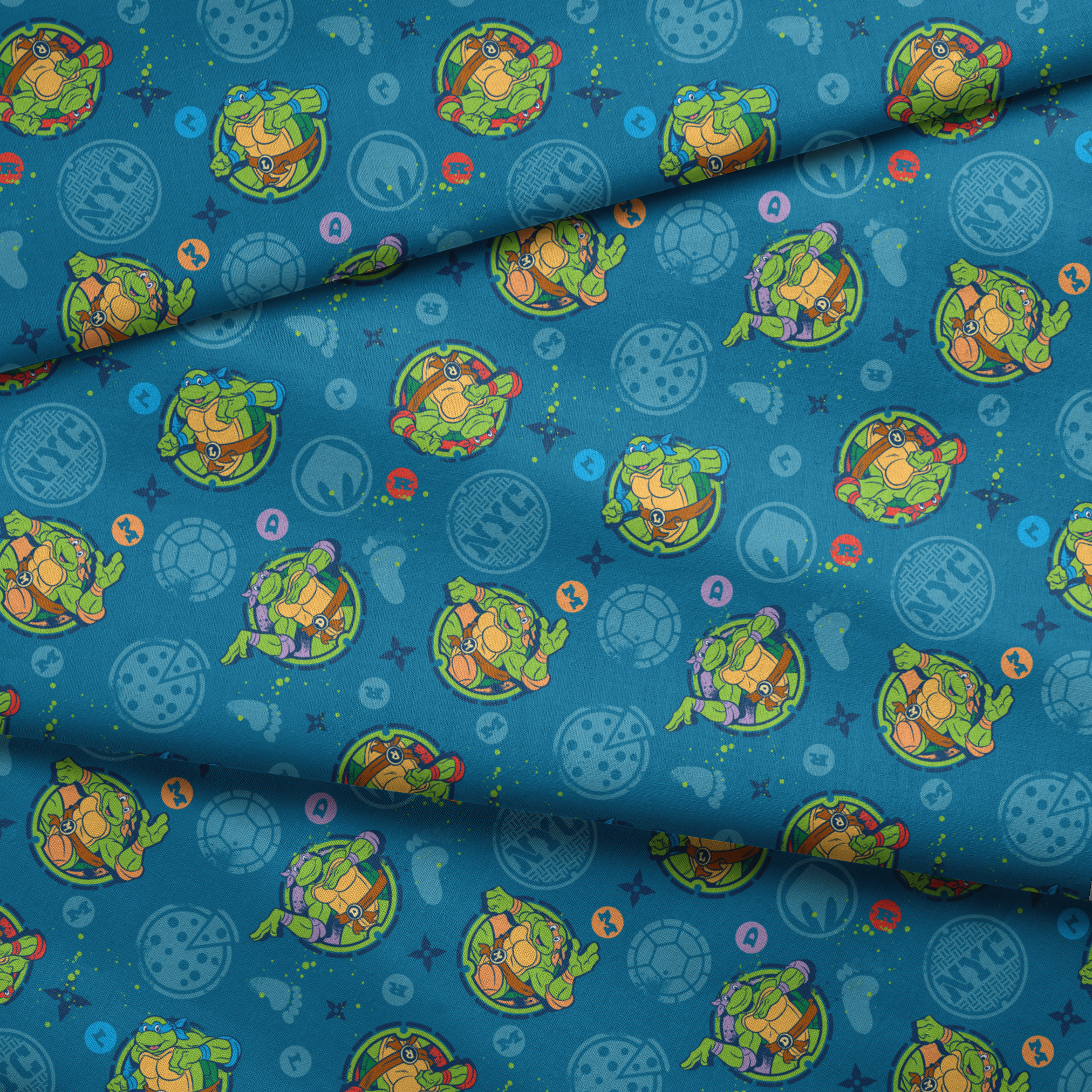 Teenage Mutant Ninja Turtles in circular medallions on teal background with subtle geometric patterns fabric fold mockup