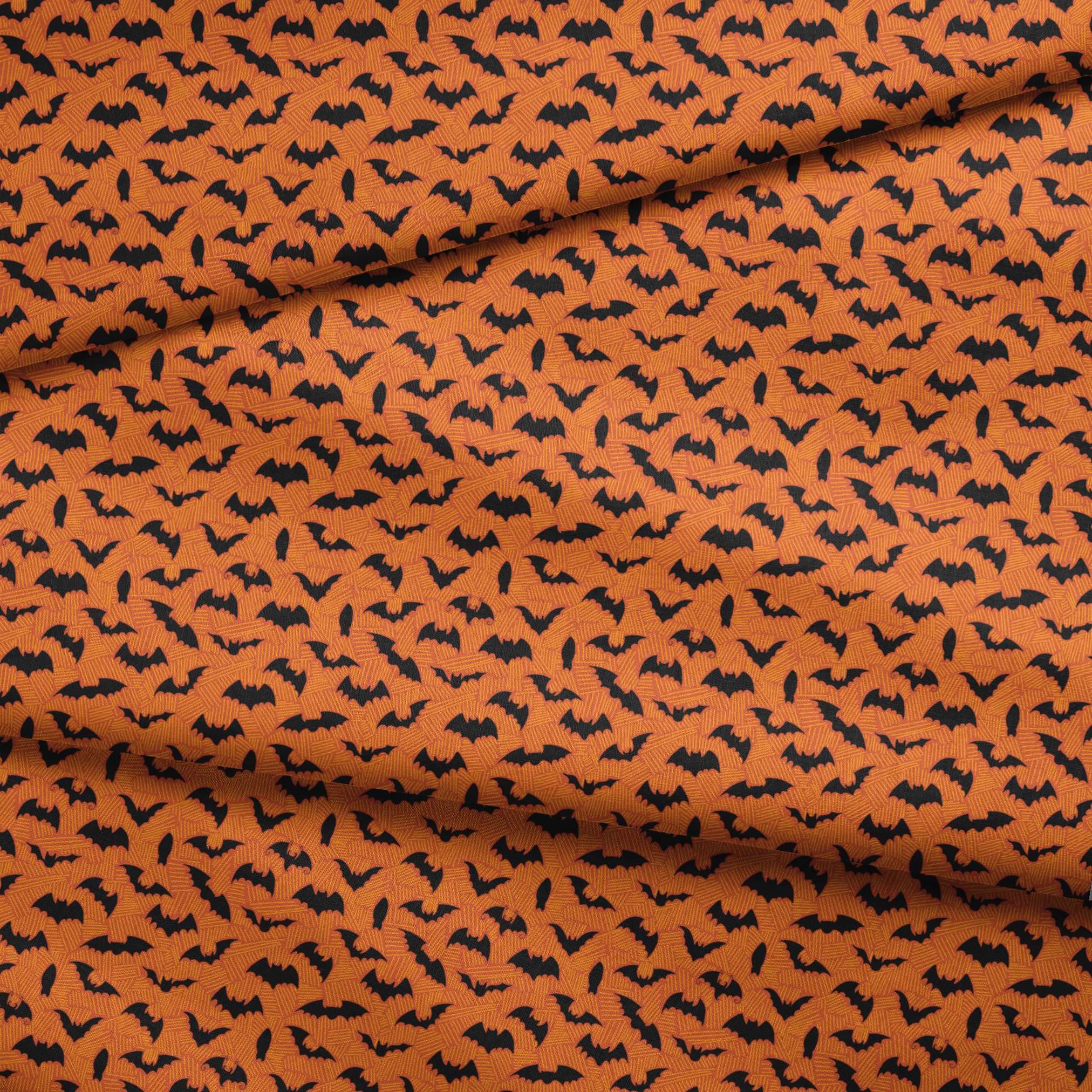 Halloween pattern with black bats scattered across an orange textured background fabric fold mockup