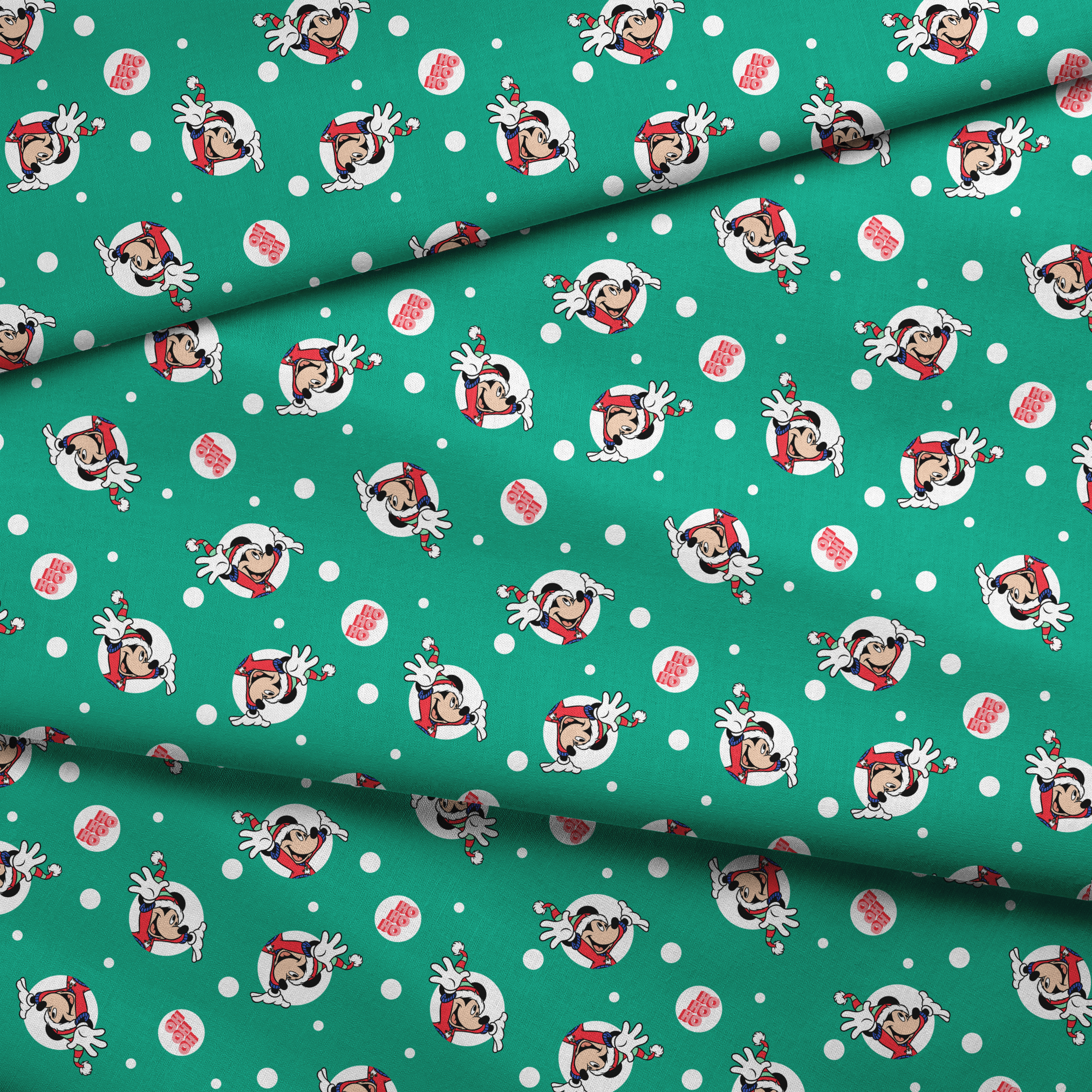 Mickey Mouse in Santa hats on green polka dot background with "Ho Ho Ho" text fabric fold mockup