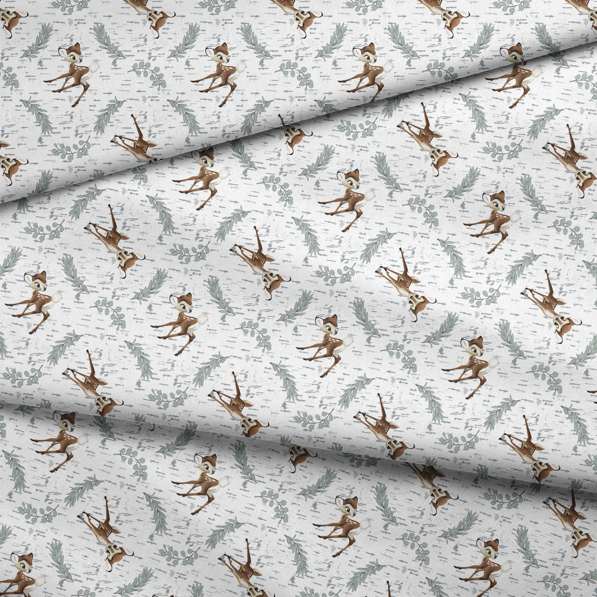 Disney’s Bambi surrounded by sage green sprigs, leafy branches, and birch bark textures on a white background in a woodland-themed scattered repeat. fabric fold mockup
