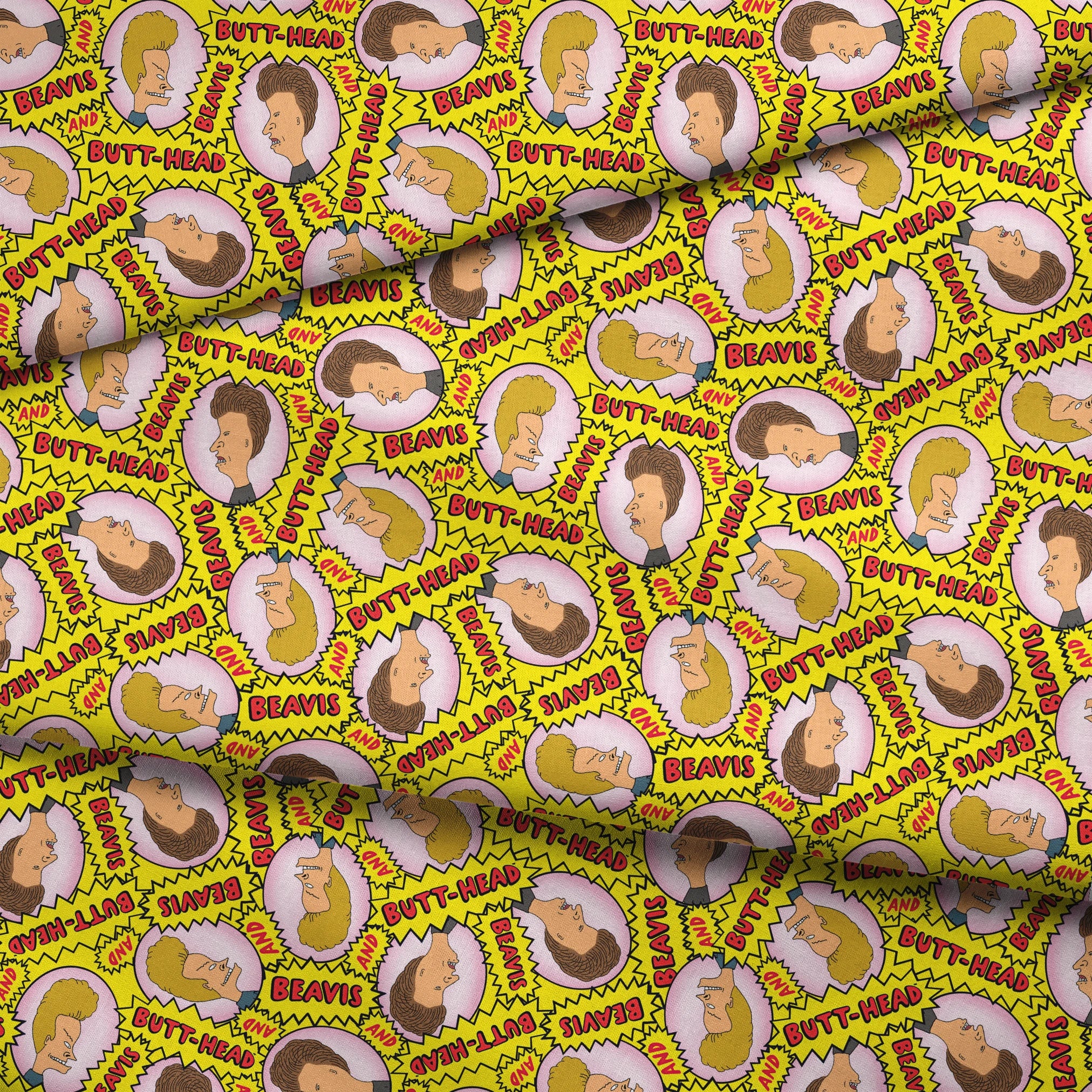 Yellow pattern with cartoon characters and text "BEAVIS" and "BUTT-HEAD" in comic-style speech bubbles repeated throughout fabric fold mockup