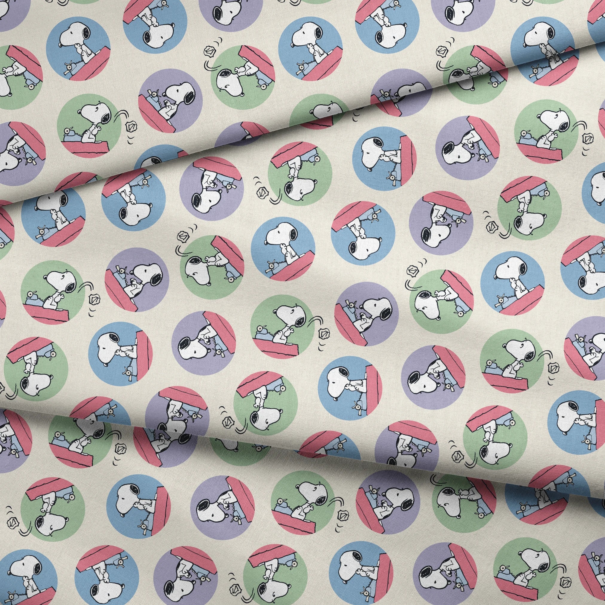 Cartoon Snoopy pattern with the beagle character in circular frames of blue, green, and purple backgrounds fabric fold mockup