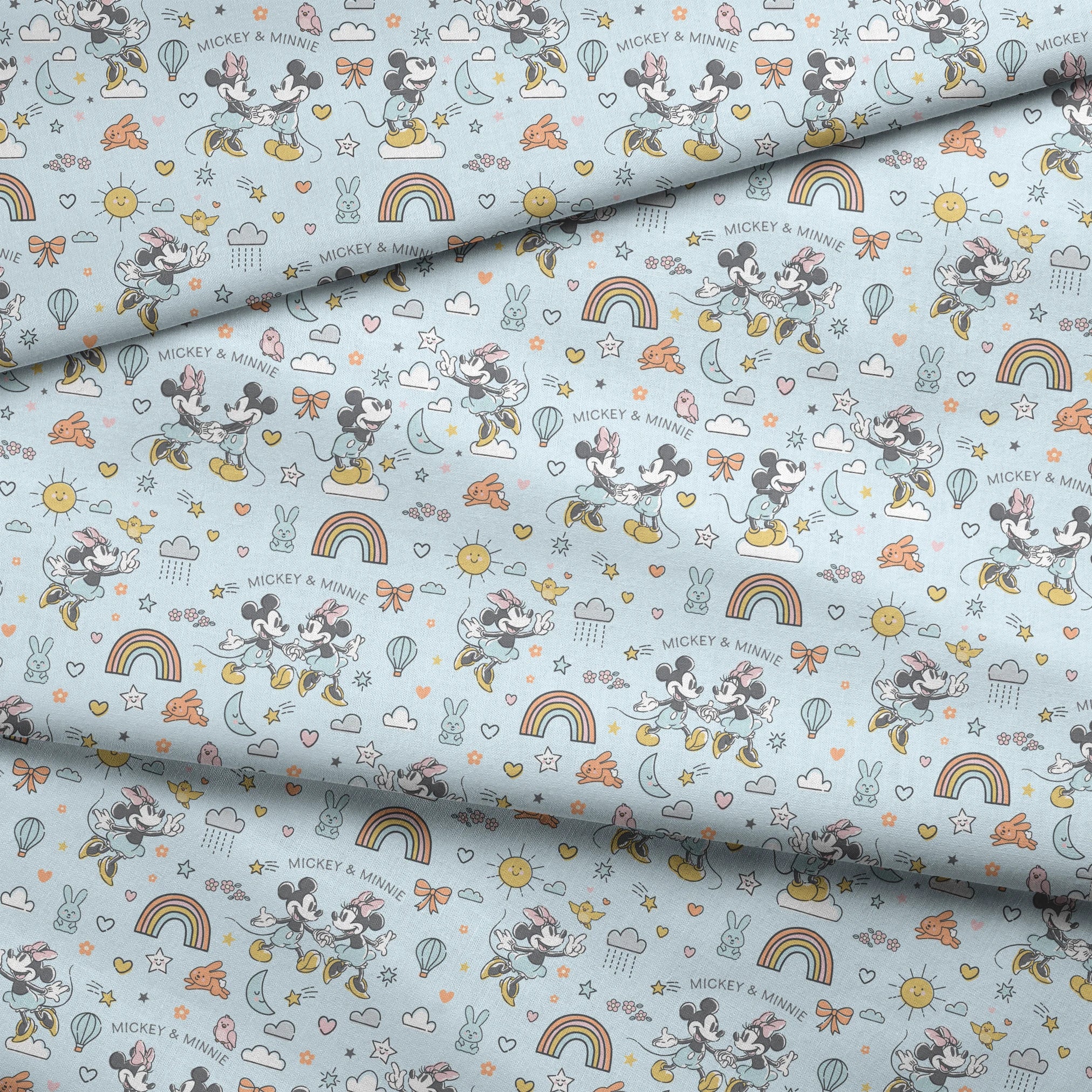 Playful Disney pattern with classic cartoon characters, rainbows, hearts, and whimsical elements on light blue background. fabric fold mockup
