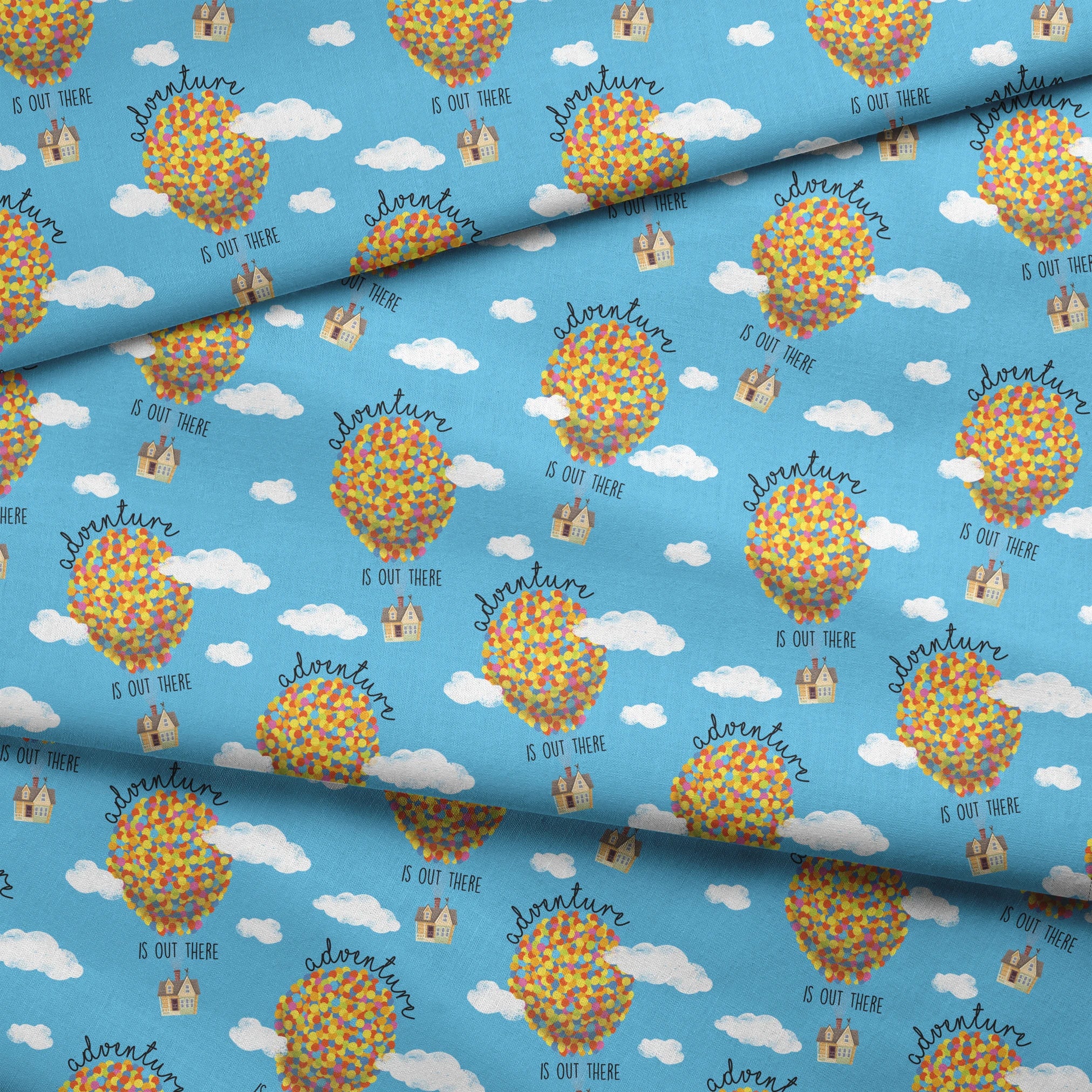 Colorful Up-inspired balloon houses floating in blue sky with text "Adventure is out there" repeating in pattern fabric fold mockup