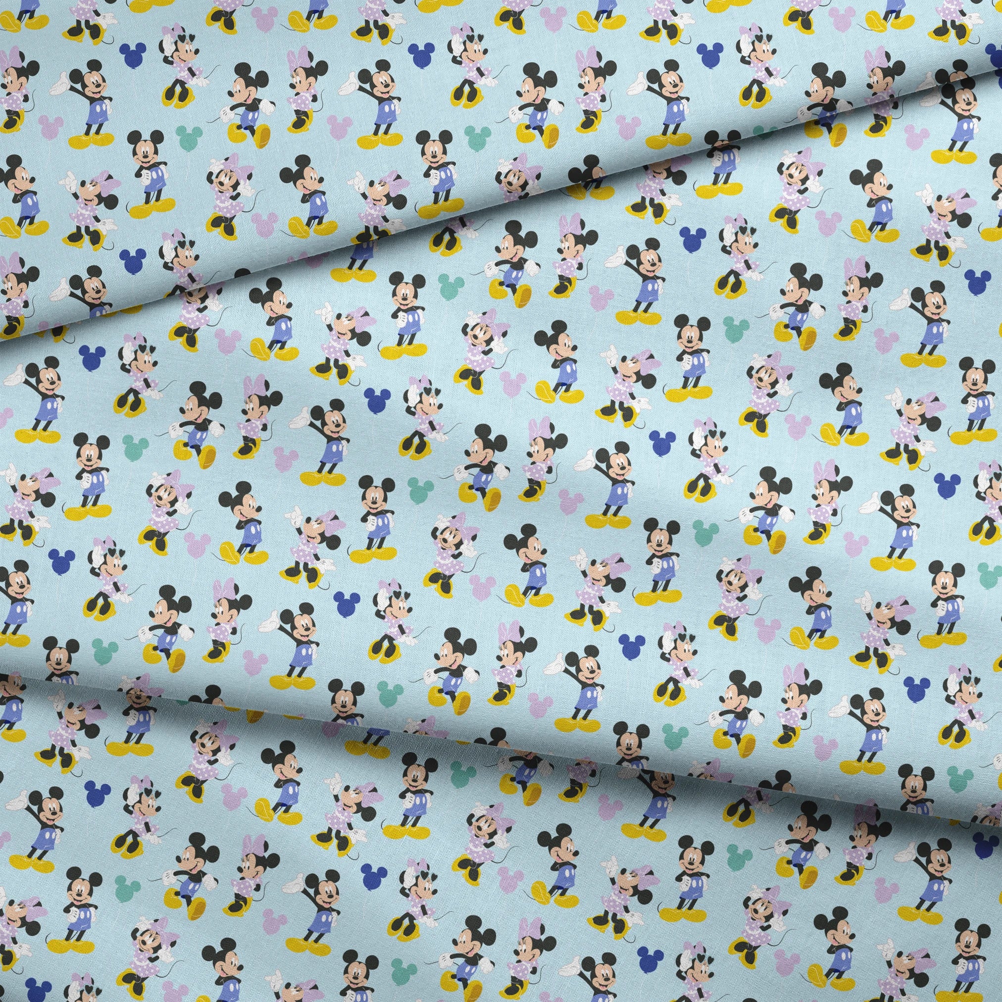 Pattern of Mickey and Minnie Mouse characters in various poses on light blue background fabric fold mockup