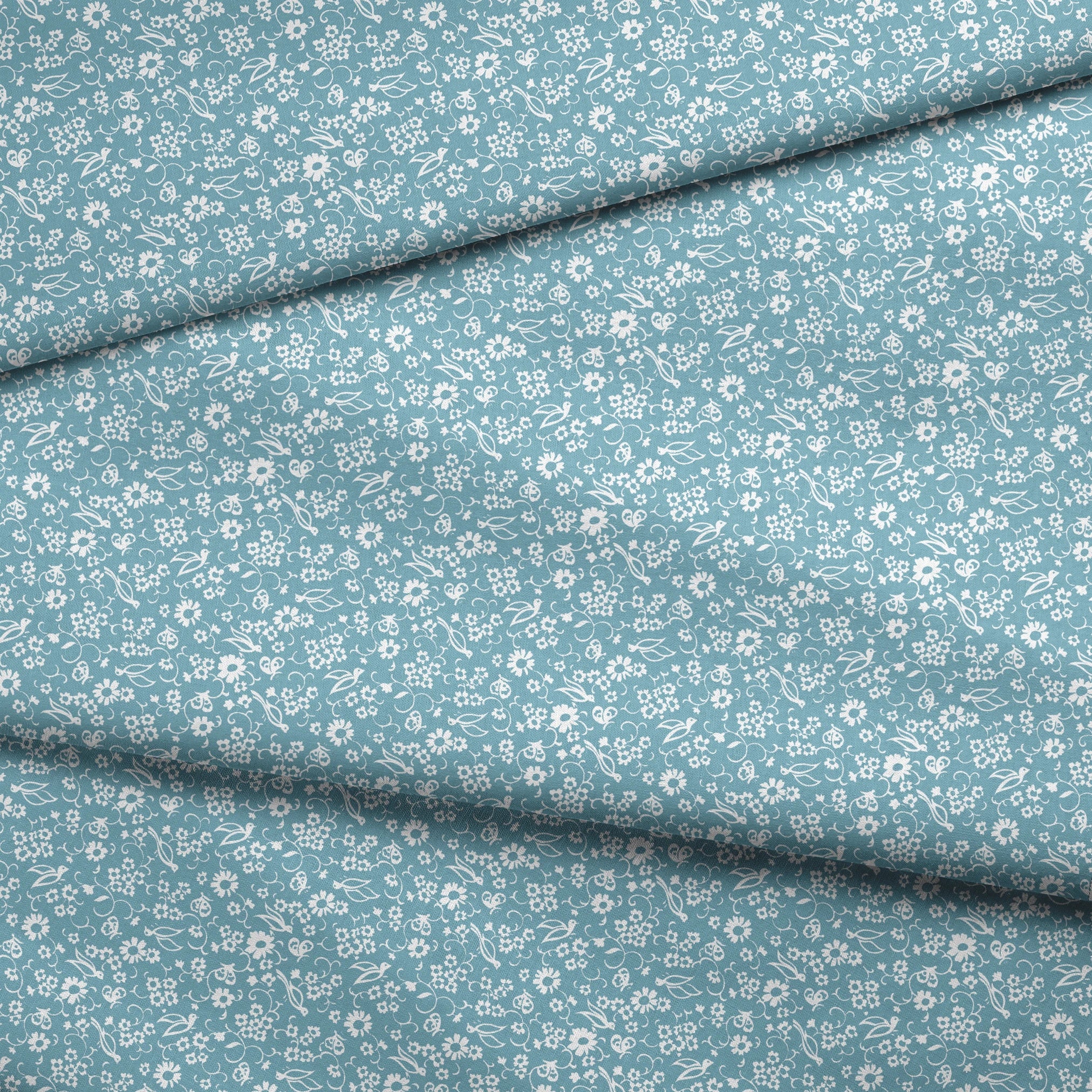 White vintage-style bird and floral silhouettes on a dusty blue background. fabric fold mockup