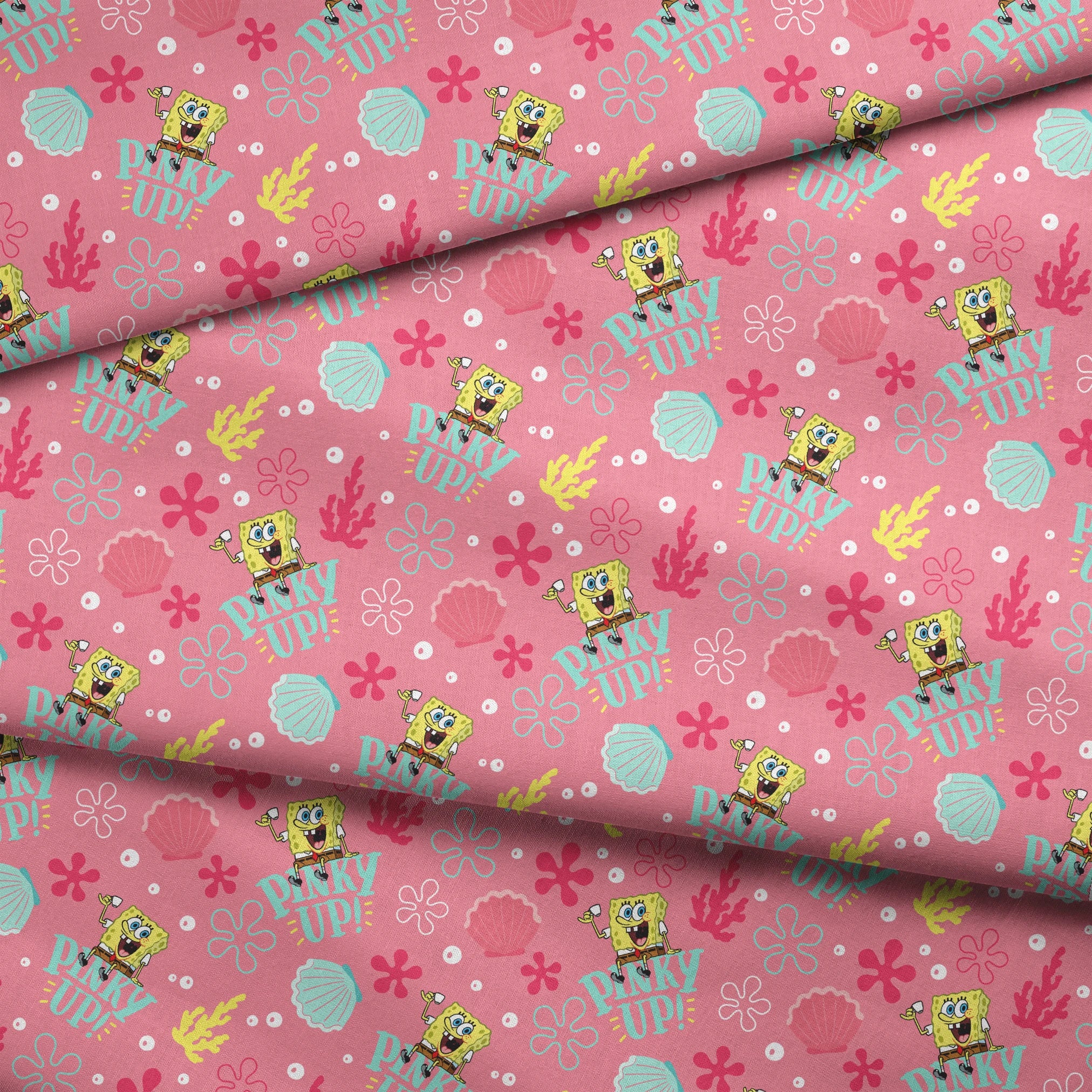 SpongeBob holding a teacup with “Pinky Up!” text, surrounded by sea shells, coral, and flower shapes on a pink background. fabric fold mockup