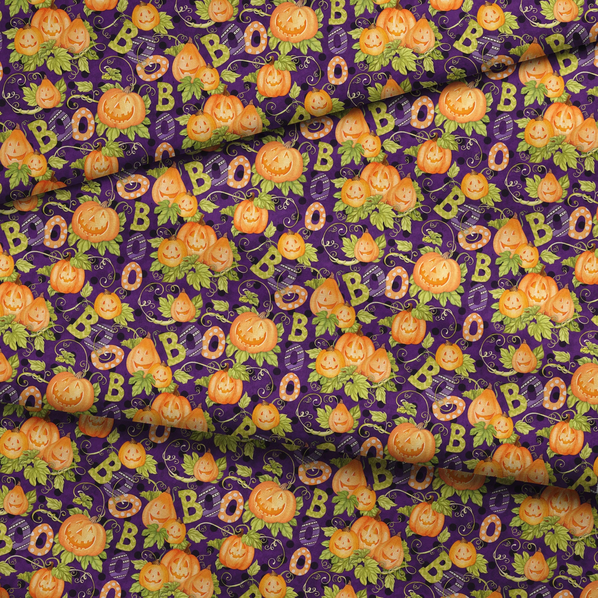 Halloween fabric by Nicole Tamarin with smiling jack-o’-lanterns, “BOO” text, vines, and leaves on a purple background. fabric fold mockup