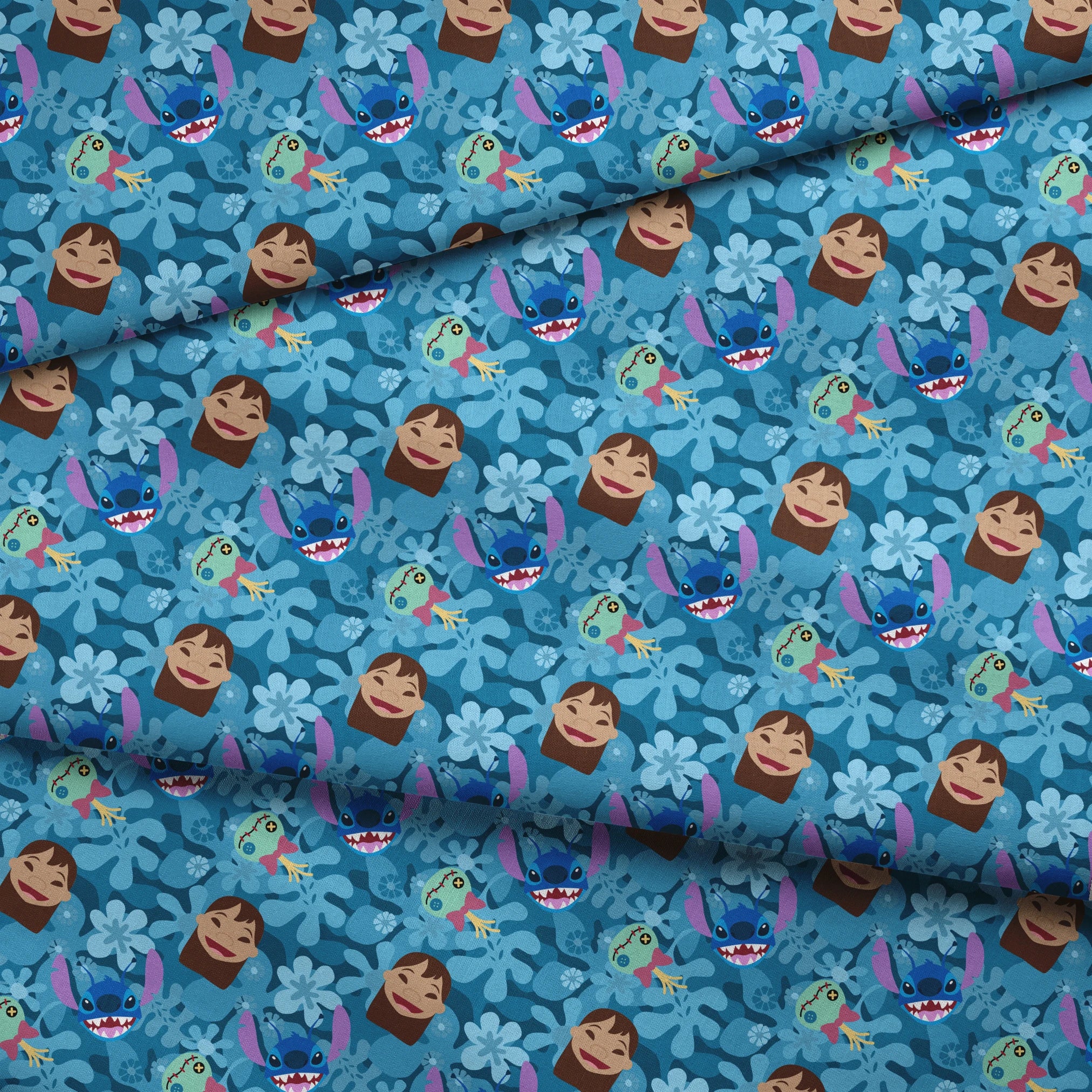 Disney's Stitch among floral elements and smiling faces on turquoise background fabric fold mockup