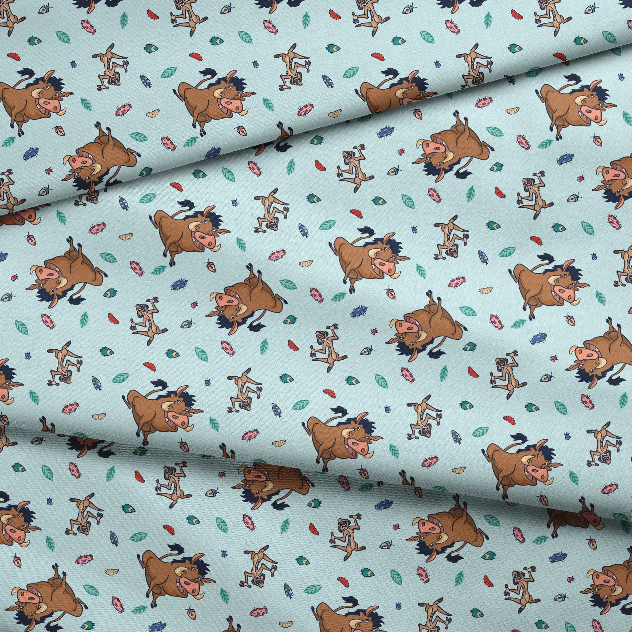 Lion King characters and colorful leaves scattered on light blue background in playful pattern fabric fold mockup