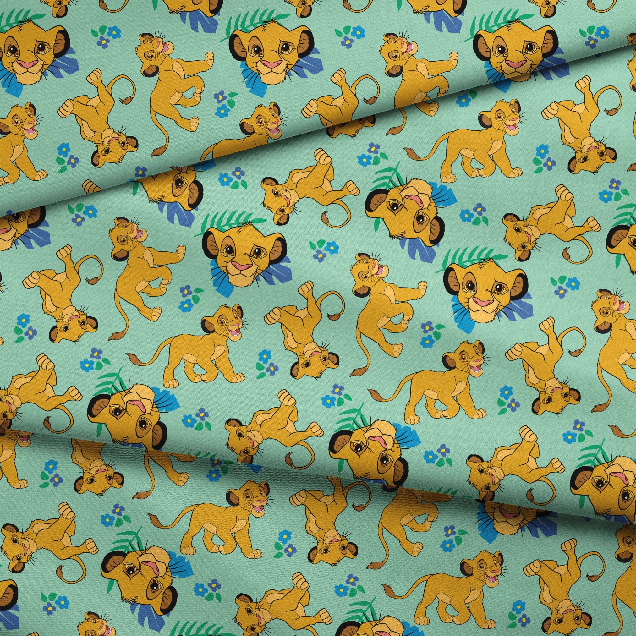 Cartoon lion cubs playing on mint green background with blue flowers and green leaves pattern fabric fold mockup