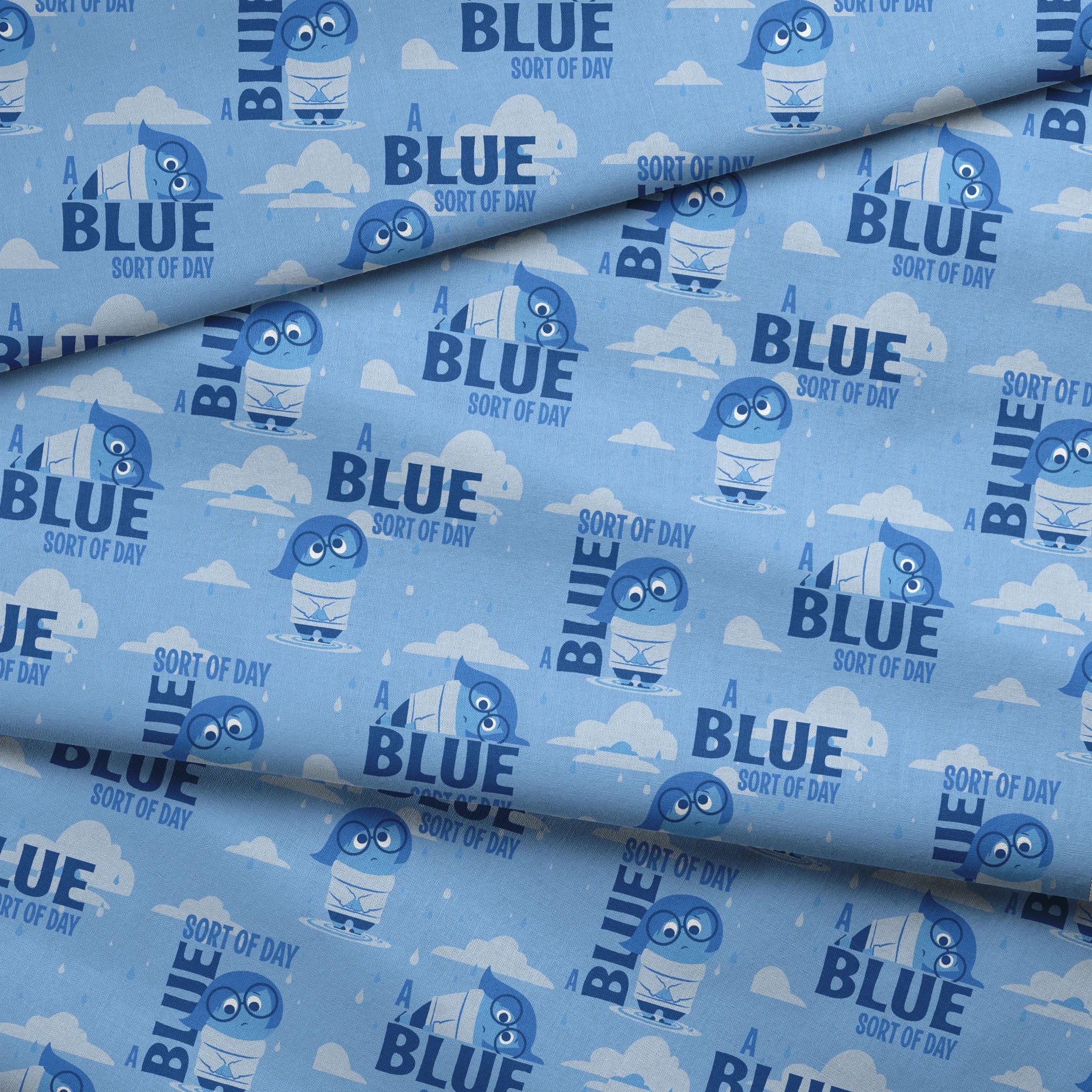 Sadness from Disney and Pixar's Inside Out pattern with "BLUE SORT OF DAY" text on light blue background with clouds fabric fold mockup