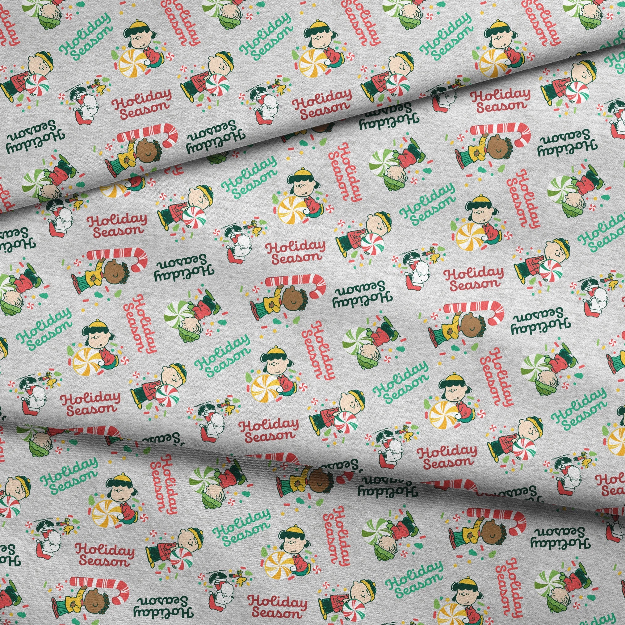 Festive Peanuts characters with candy canes and peppermints on gray background with "Holiday Season" text fabric fold mockup