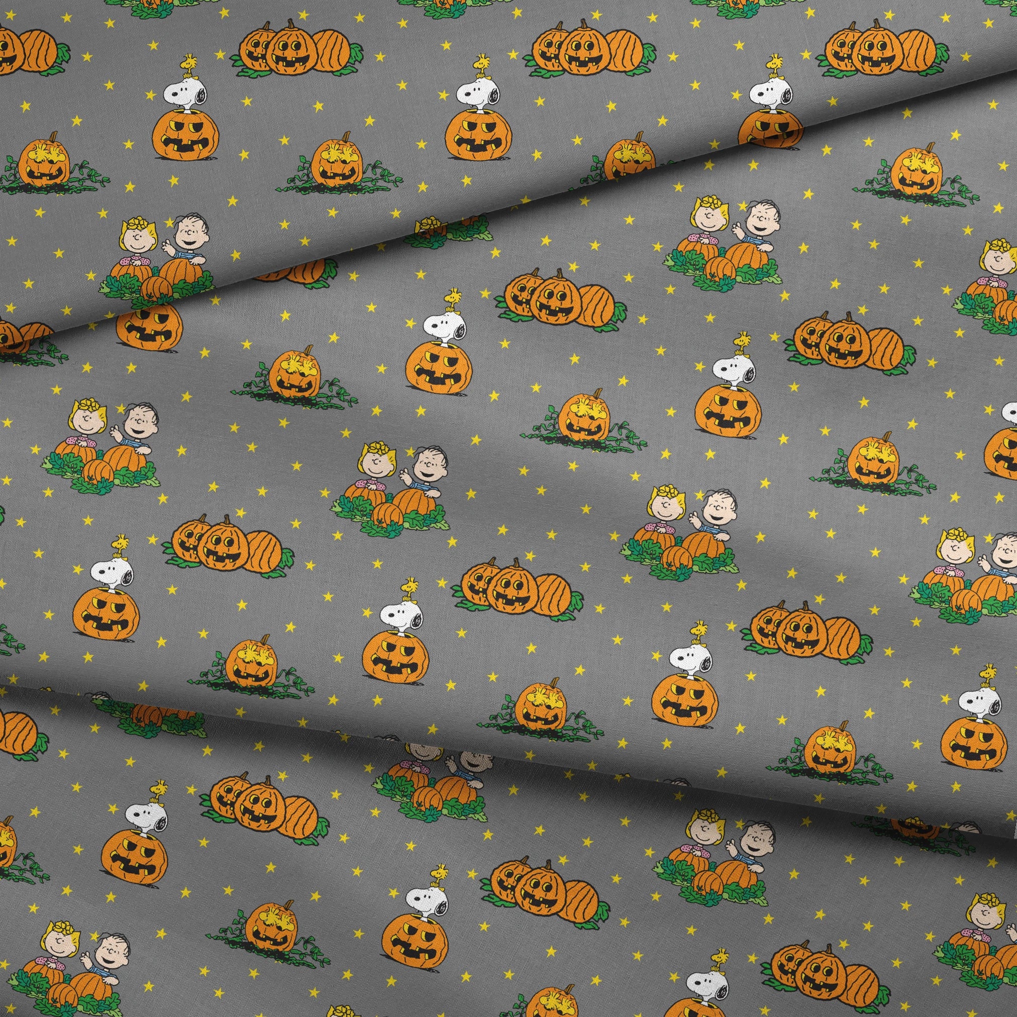 Peanuts Halloween pattern with Snoopy on pumpkins, Peanuts characters in pumpkin patches, and yellow stars on gray background. fabric fold mockup