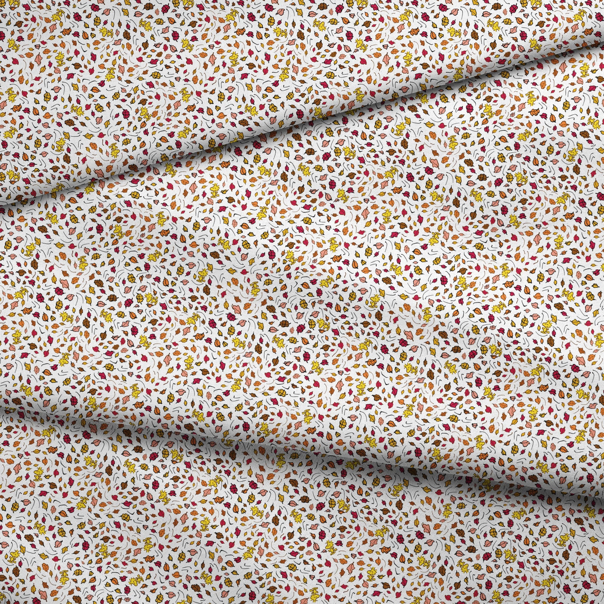 Colorful Peanuts autumn leaves pattern with Woodstock and yellow, red, and brown foliage scattered on white background fabric fold mockup