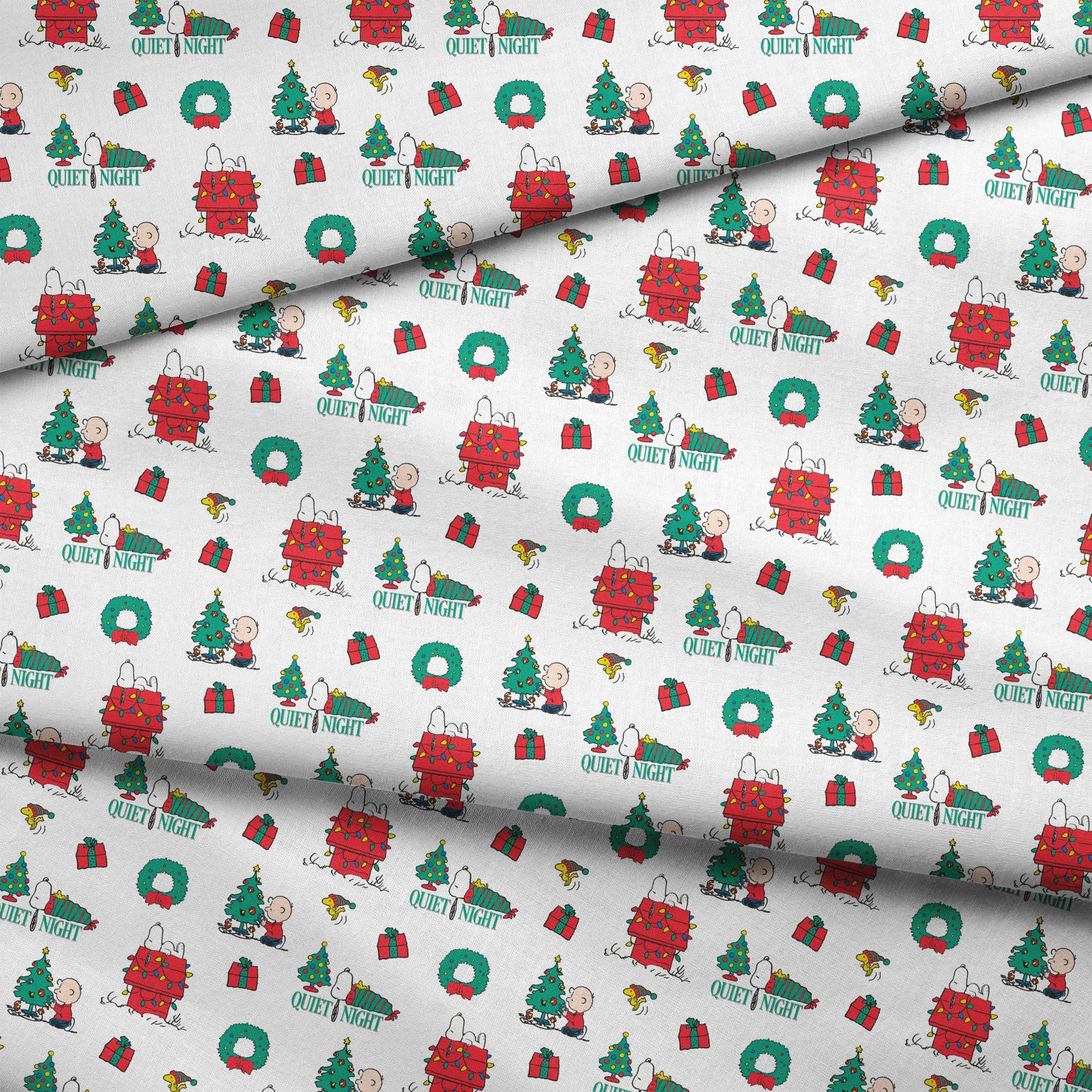 Peanuts Christmas pattern with Snoopy's decorated doghouse, trees, wreaths, and "Quiet Night" text fabric fold mockup