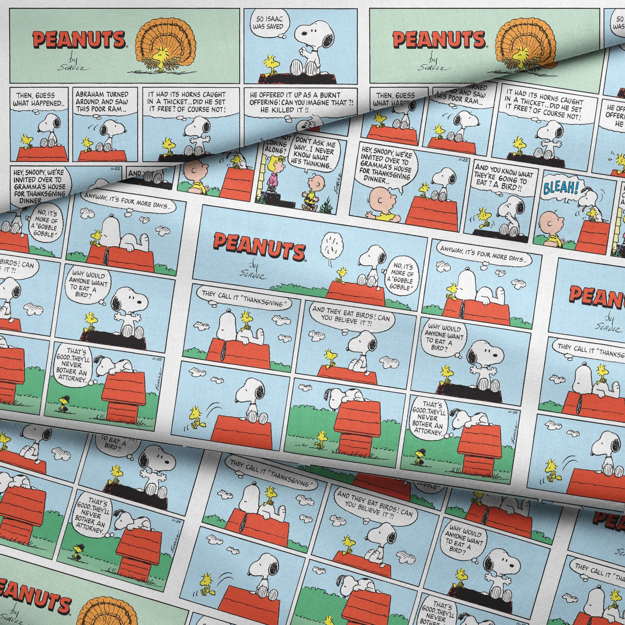 A Peanuts comic strip featuring Snoopy on his red doghouse, shown in multiple panels with Thanksgiving and food-related humor throughout the colorful Sunday format. fabric fold mockup