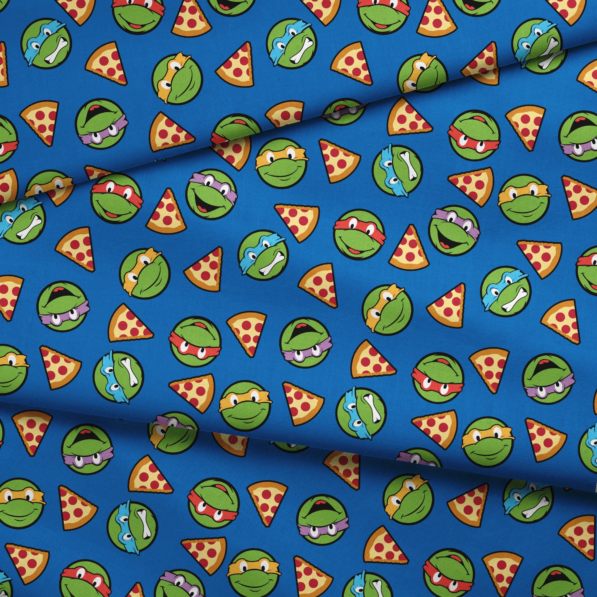 Teenage Mutant Ninja Turtle faces with colored masks and pizza slices pattern on blue background fabric fold mockup