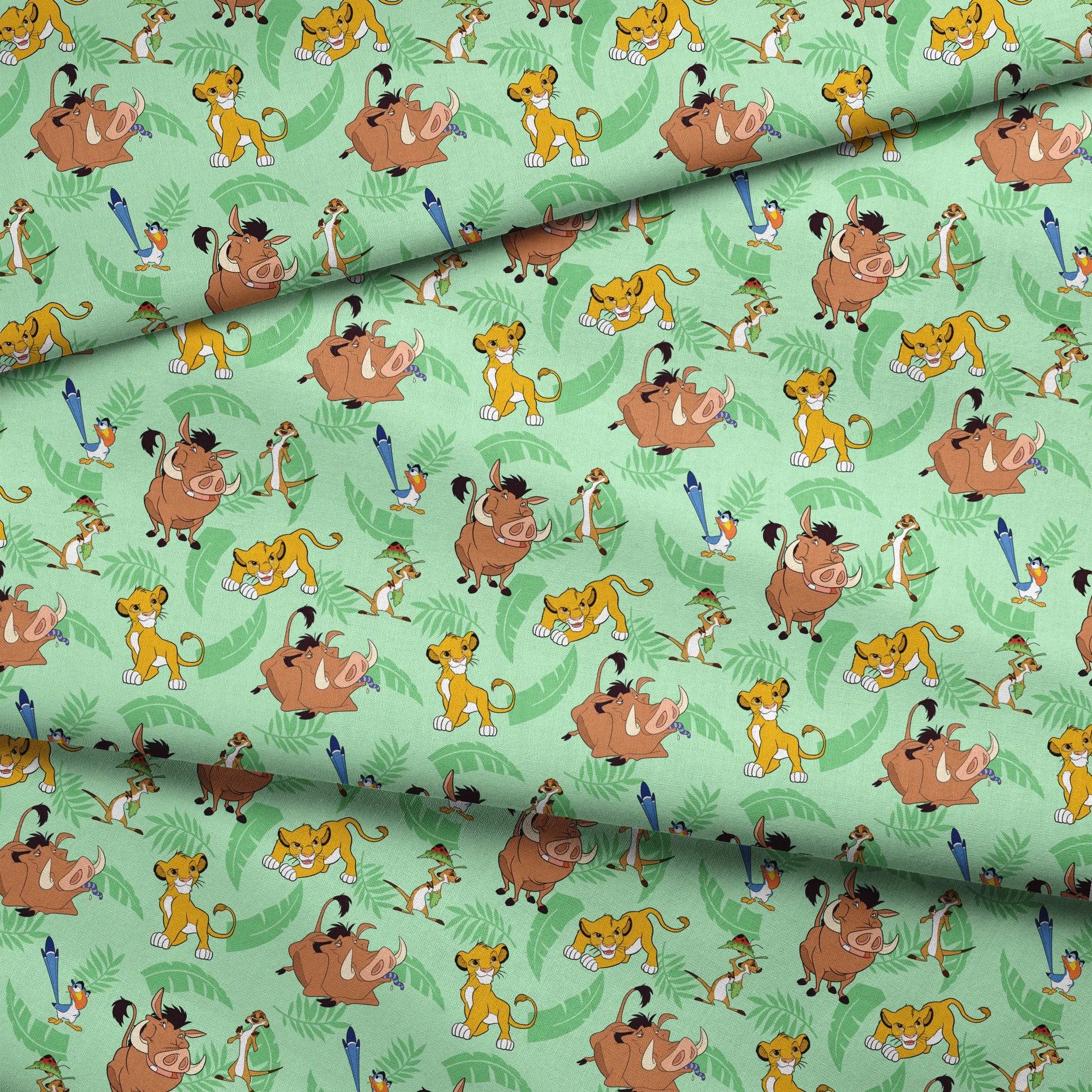 A repeating pattern of Lion King characters - Simba, Timon, Pumbaa, and Zazu on a light green leafy background. fabric fold mockup