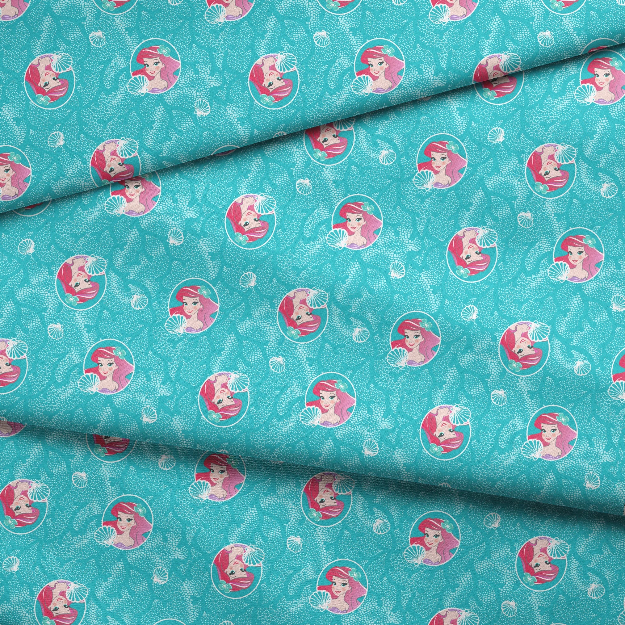 The Little Mermaid pattern with Ariel in turquoise circles on aqua background with seashells fabric fold mockup
