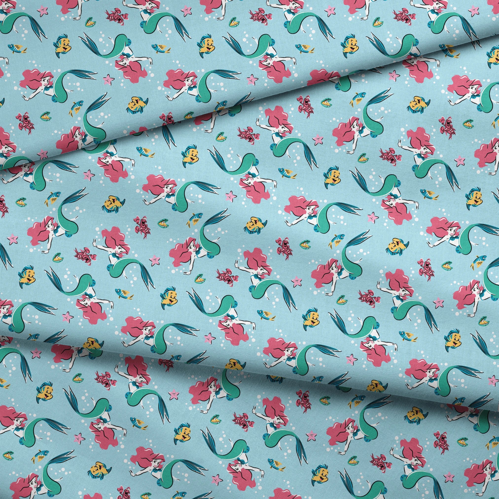 Underwater pattern with colorful mermaids, tropical fish, crabs, and starfish on light blue background fabric fold mockup
