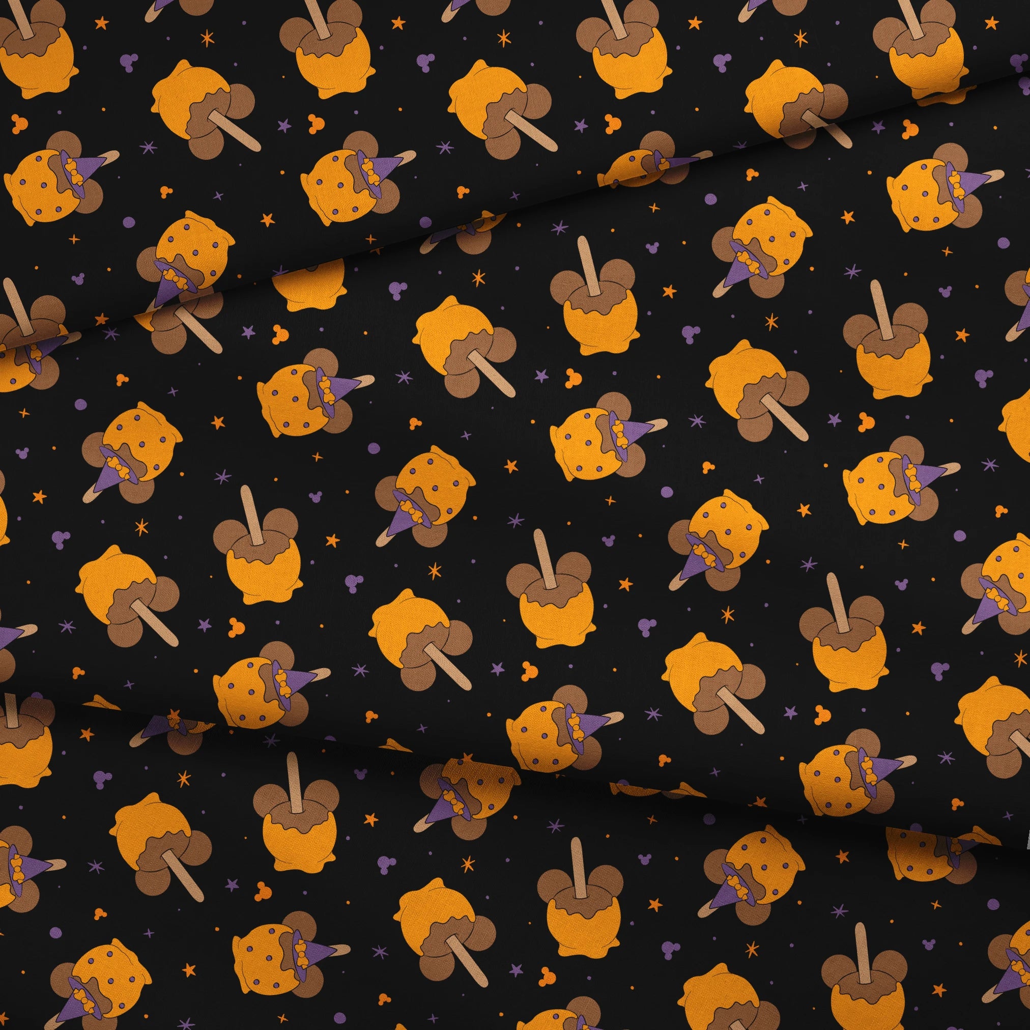 Disney-inspired caramel apples and candy apples floating in a space-like black background with purple stars. fabric fold mockup