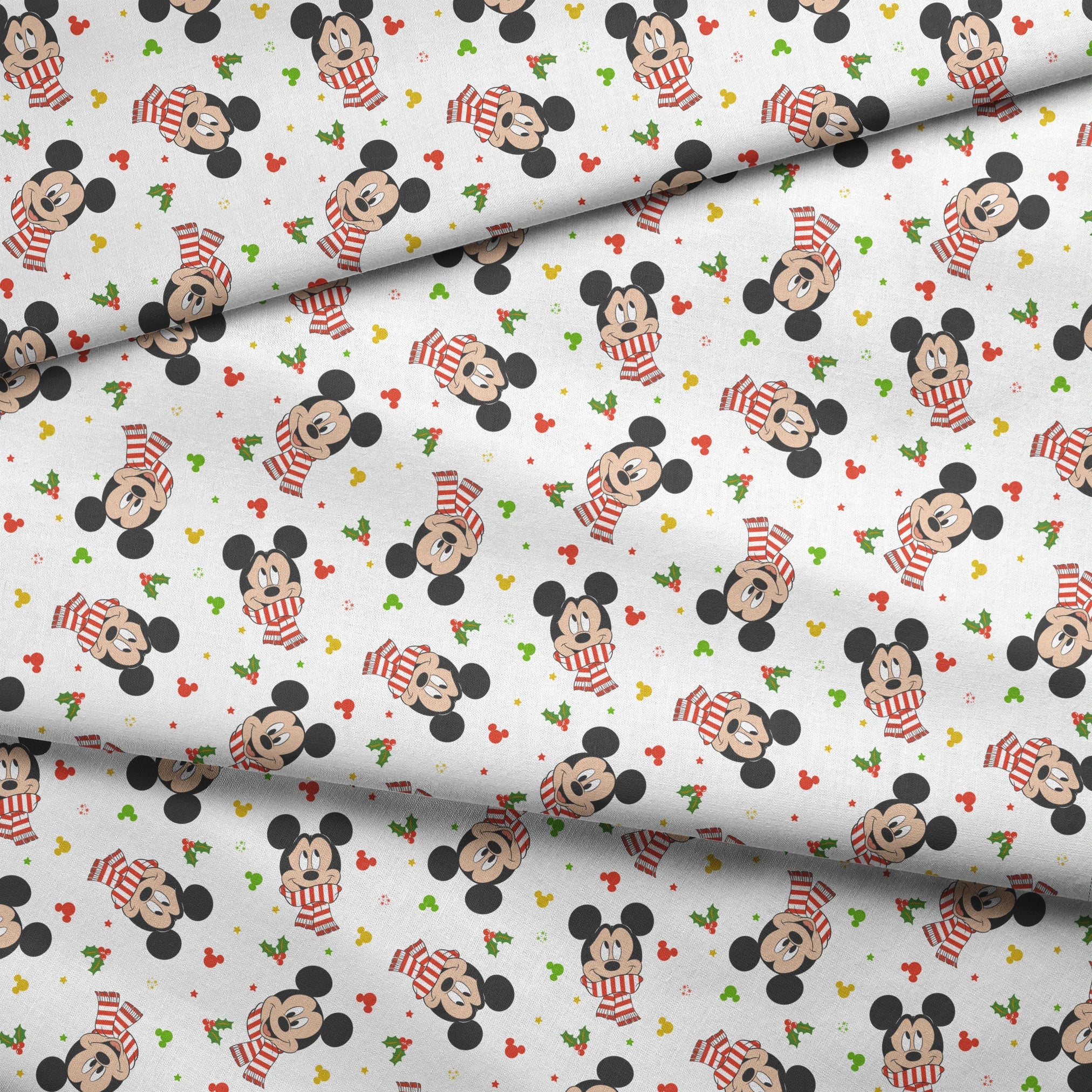 Mickey Mouse wearing red striped scarves, surrounded by holly and colorful icons on white background fabric fold mockup