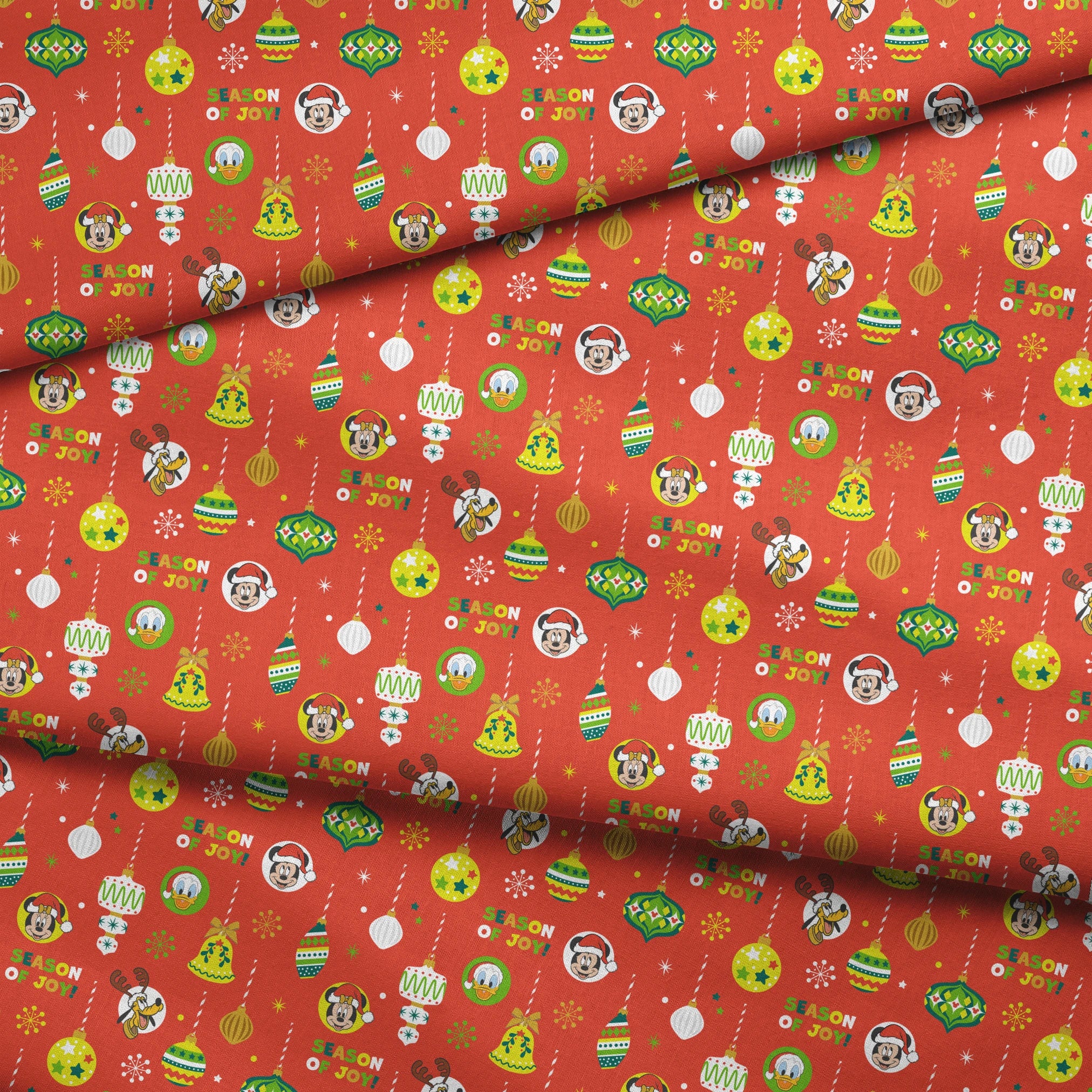 Christmas ornament pattern with colorful baubles, bells, snowflakes and Mickey Mouse characters on bright red background fabric fold mockup