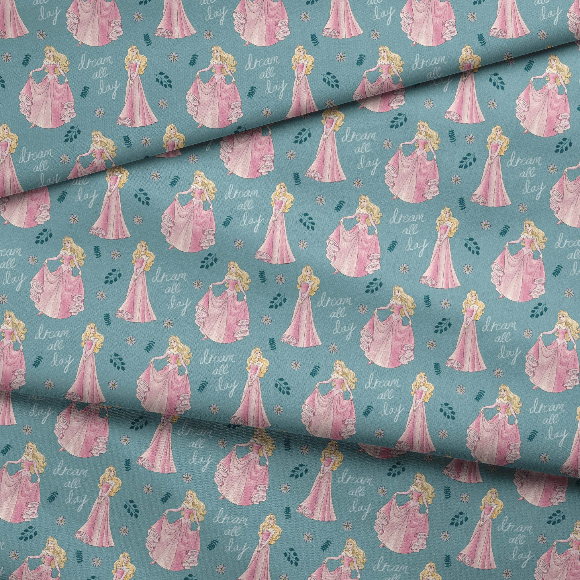 Sleeping Beauty pattern with "dream all day" text on teal background with floral elements fabric fold mockup