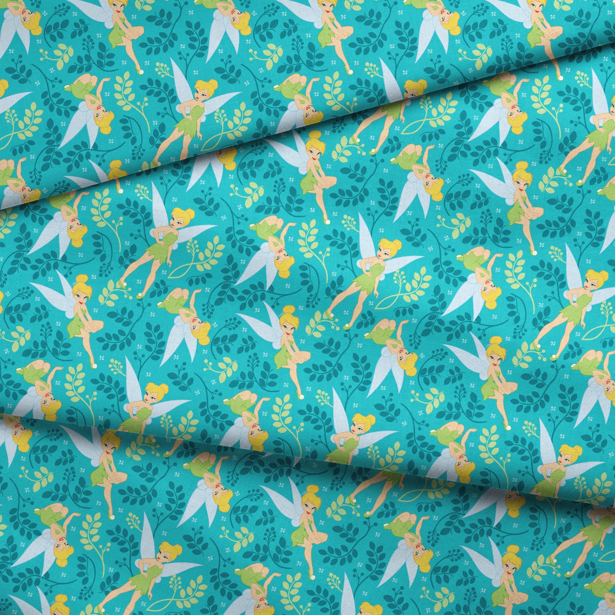 A whimsical pattern featuring Tinker Bell against a teal background with decorative green foliage and yellow accents. fabric fold mockup