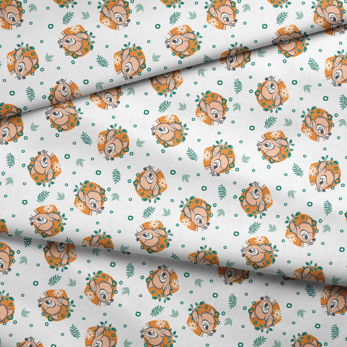 Disney’s Bambi illustrated in golden-orange floral medallions with green leaves and scattered geometric accents on a white background. fabric fold mockup