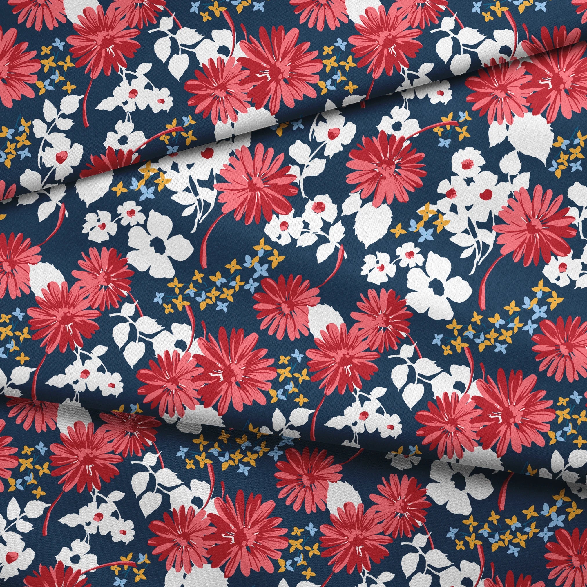 Vibrant floral pattern with red daisies and white flowers on navy background with small gold stars fabric fold mockup