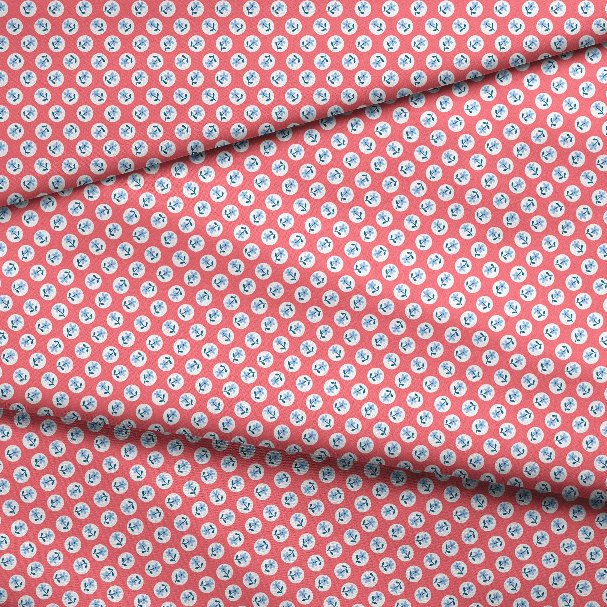 Coral pink background with white circles containing light blue floral designs arranged in a pattern fabric fold mockup