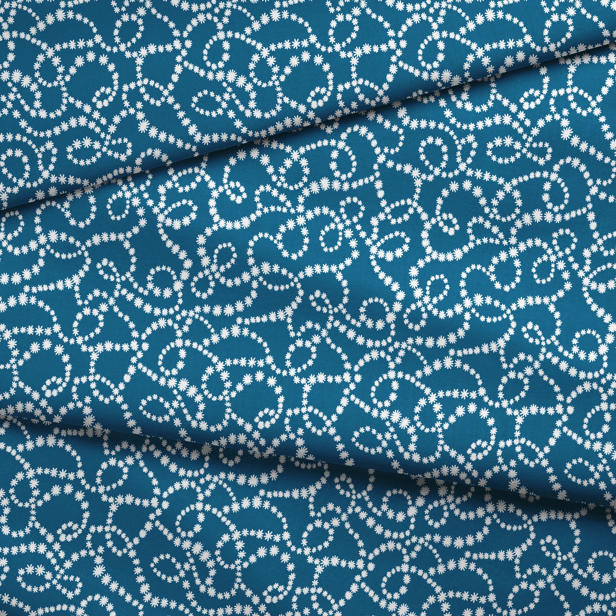 Dotted white swirling patterns on deep teal blue background creating abstract curved designs fabric fold mockup