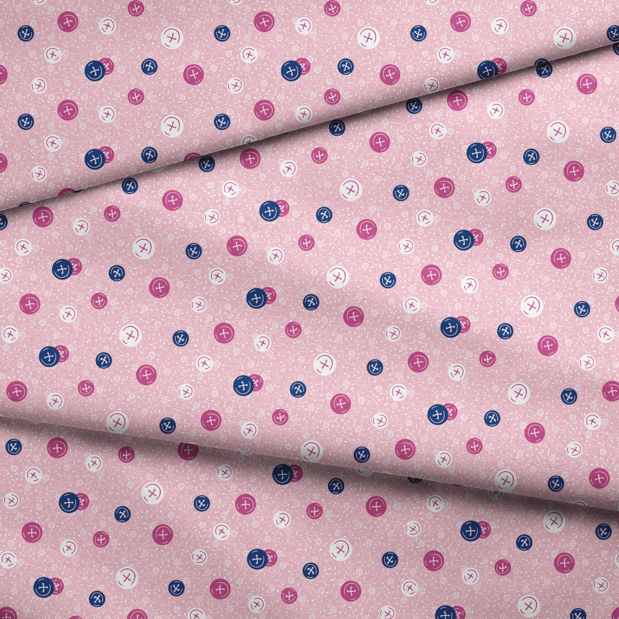 Scattered buttons in white, pink, and navy on a light pink floral background fabric fold mockup
