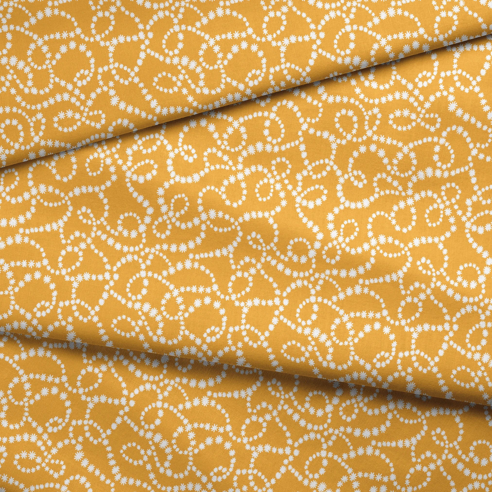 Mustard yellow background with swirling dotted white patterns forming organic circular designs fabric fold mockup