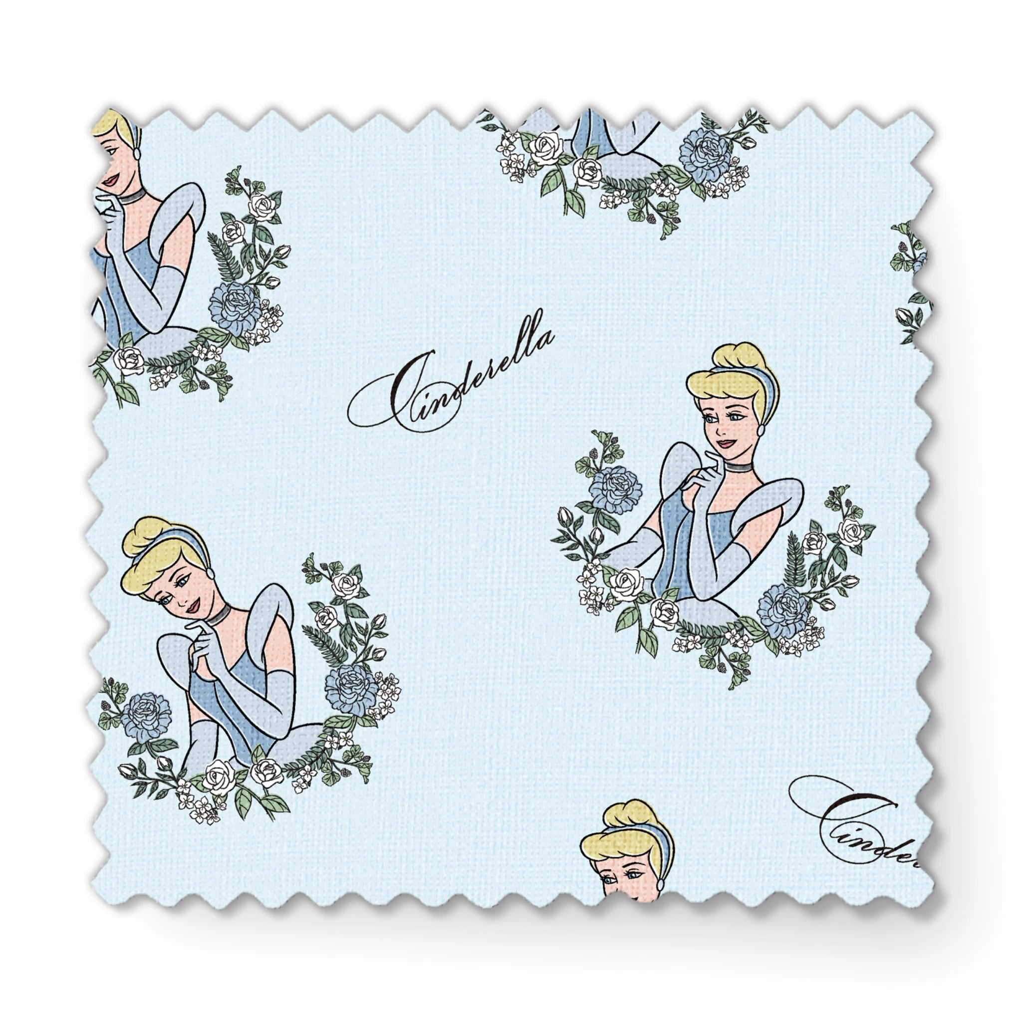 The image shows a pattern featuring a cartoon princess character in a blue dress surrounded by decorative green wreaths on a light blue background. The word "Cinderella" appears in cursive script throughout the design. fabric swatch mockup