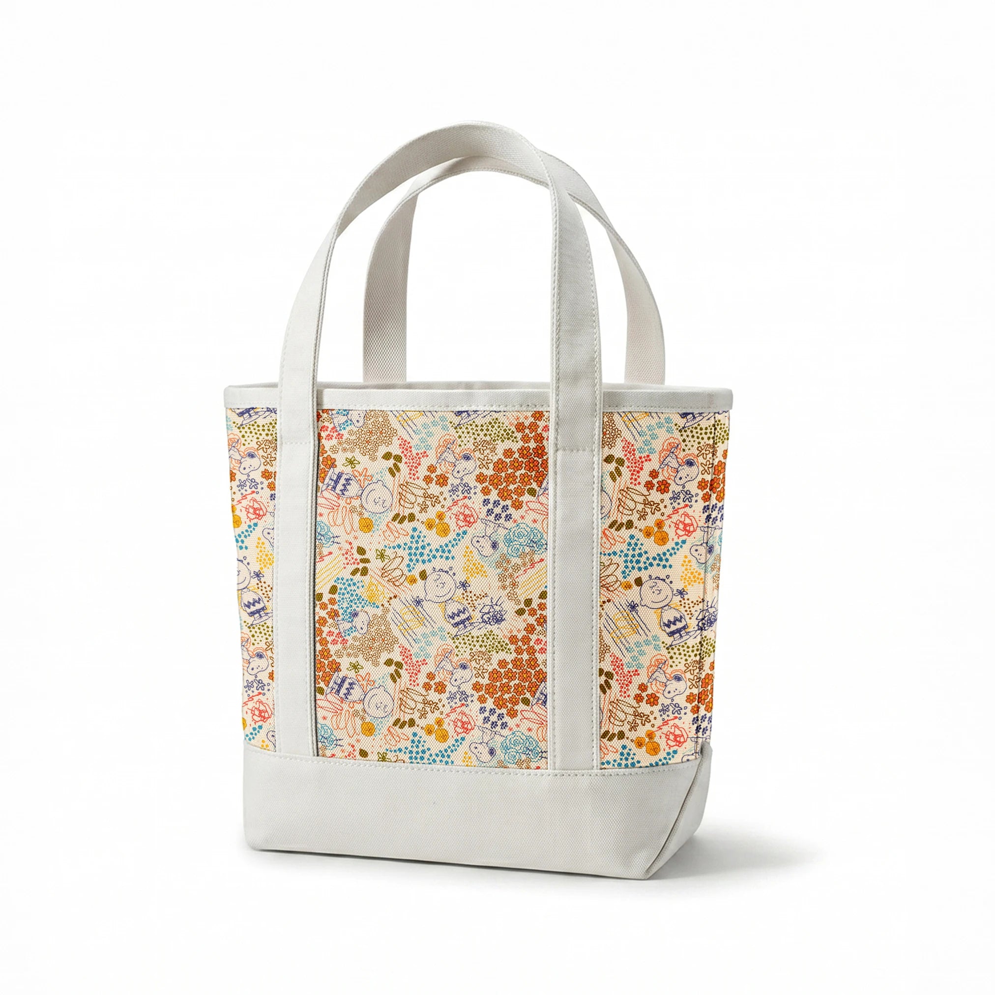 Colorful pattern with Peanuts characters sketches, floral designs, and dots in orange, blue, yellow, and green on a cream background springs canvastote mockup