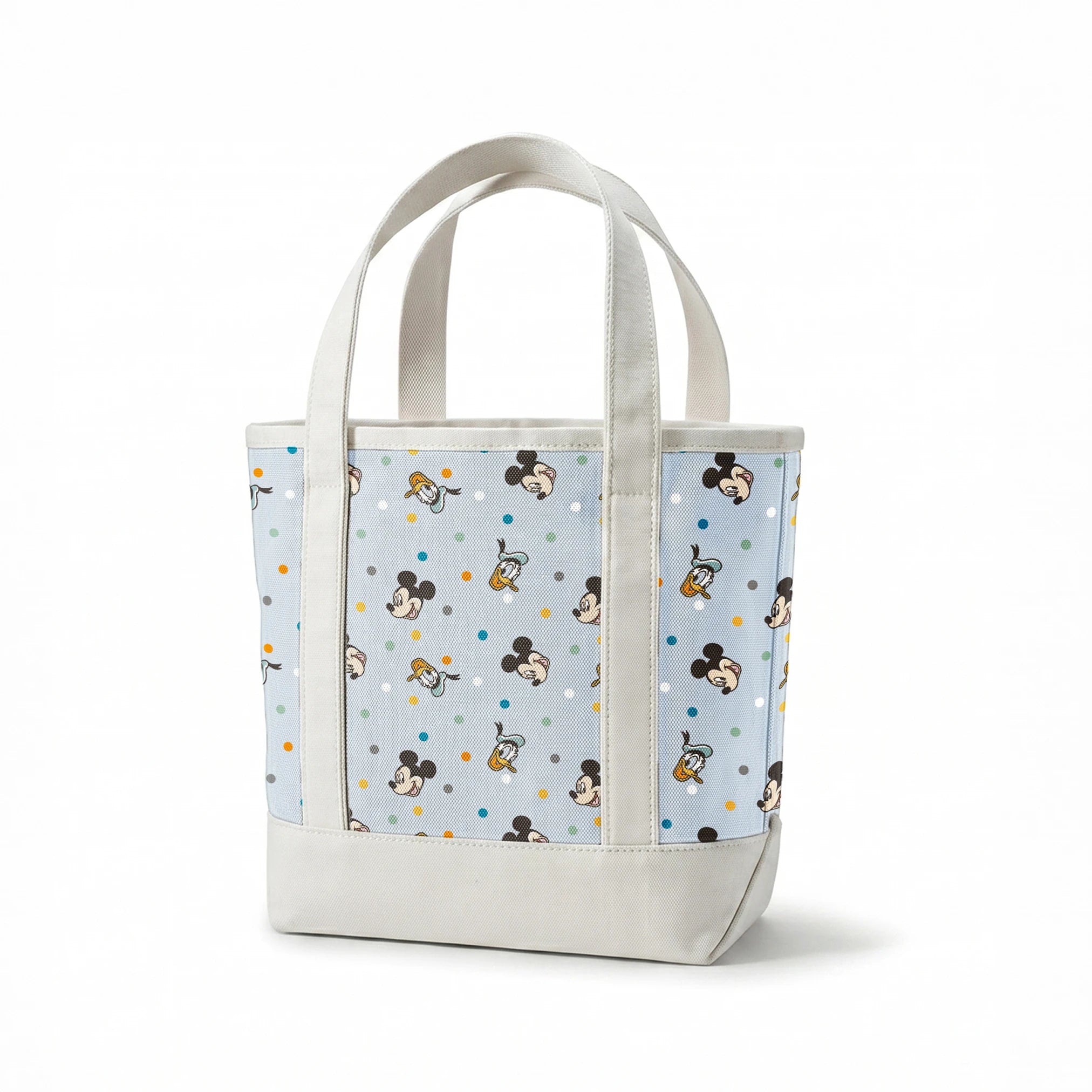Disney character pattern with Mickey Mouse and Donald Duck heads scattered on light blue background with colorful polka dots springs canvastote mockup