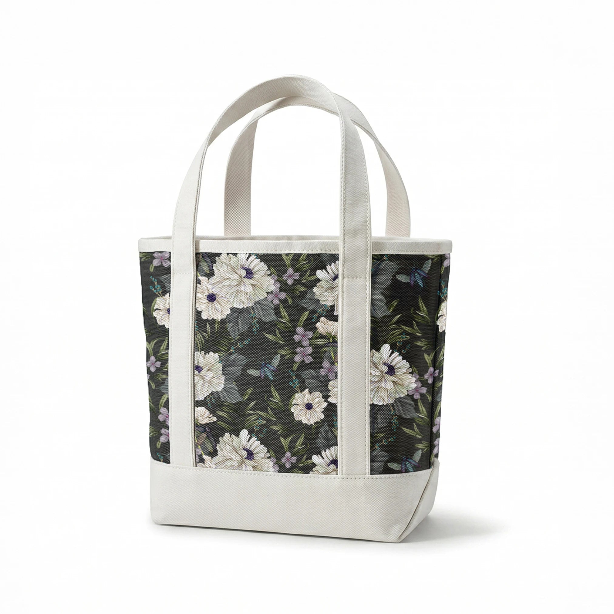 Ivory flowers with purple centers, beetles, and greenery illustrated on a dark charcoal background in a floral pattern by Nicole Tamarin. springs canvastote mockup