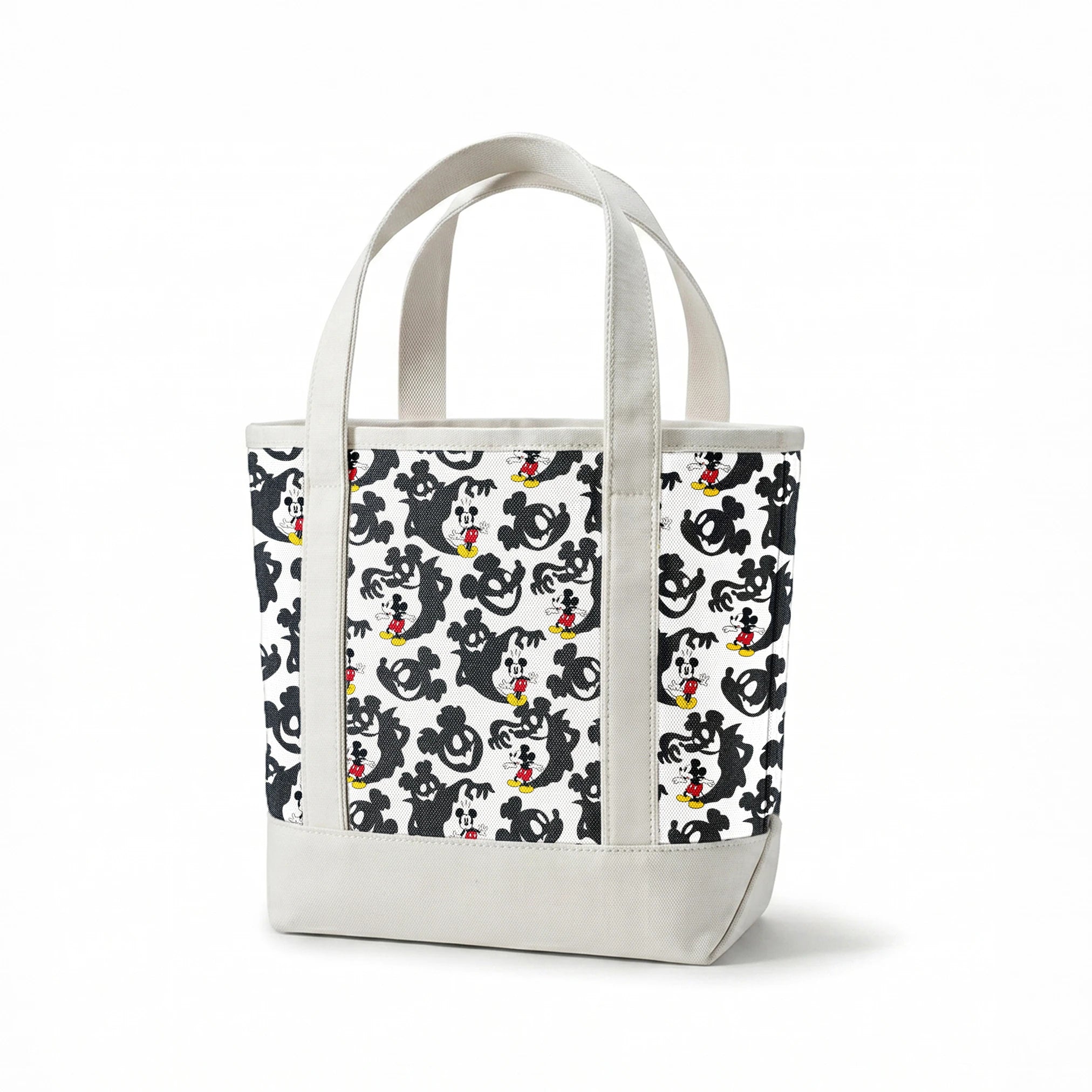 Mickey Mouse pattern with black ghost silhouettes on white background springs canvastote mockup