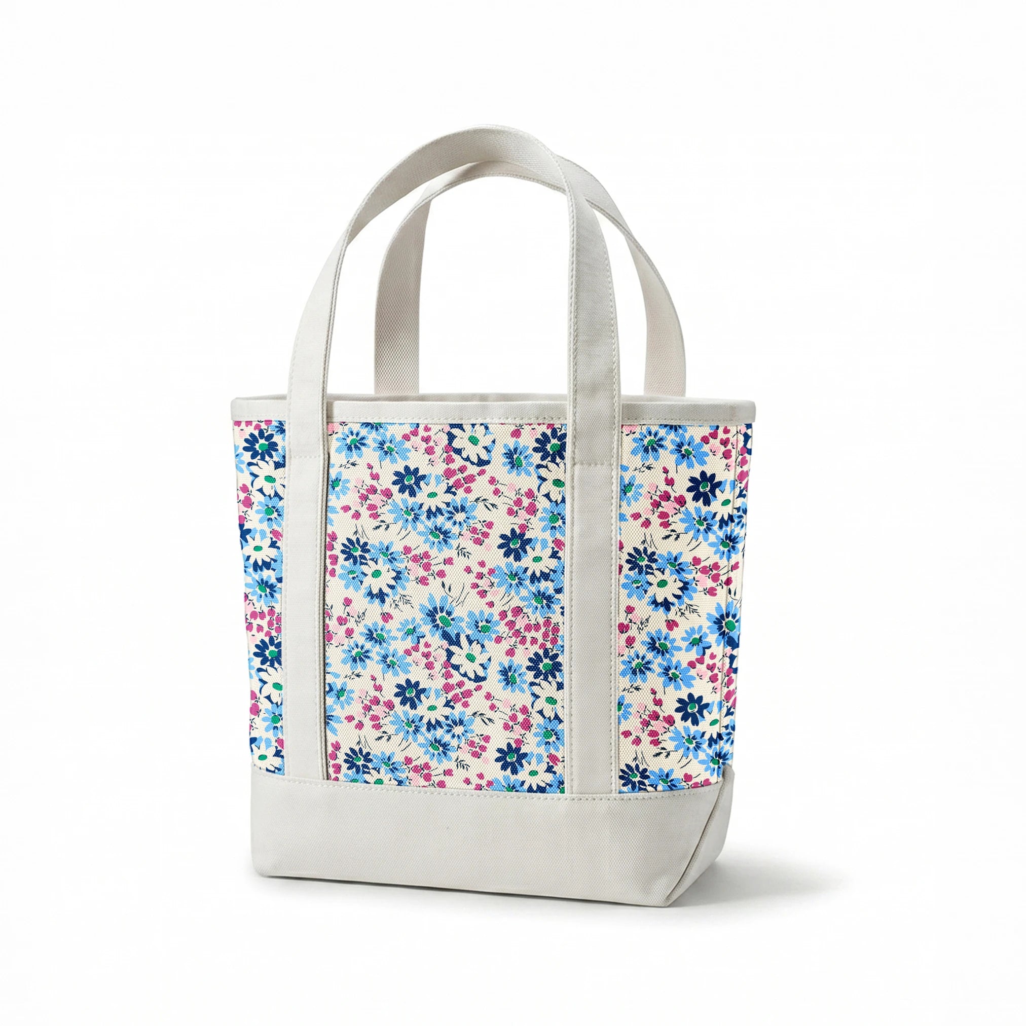 Floral pattern with blue, navy, and white daisies alongside small magenta berries on cream background springs canvastote mockup