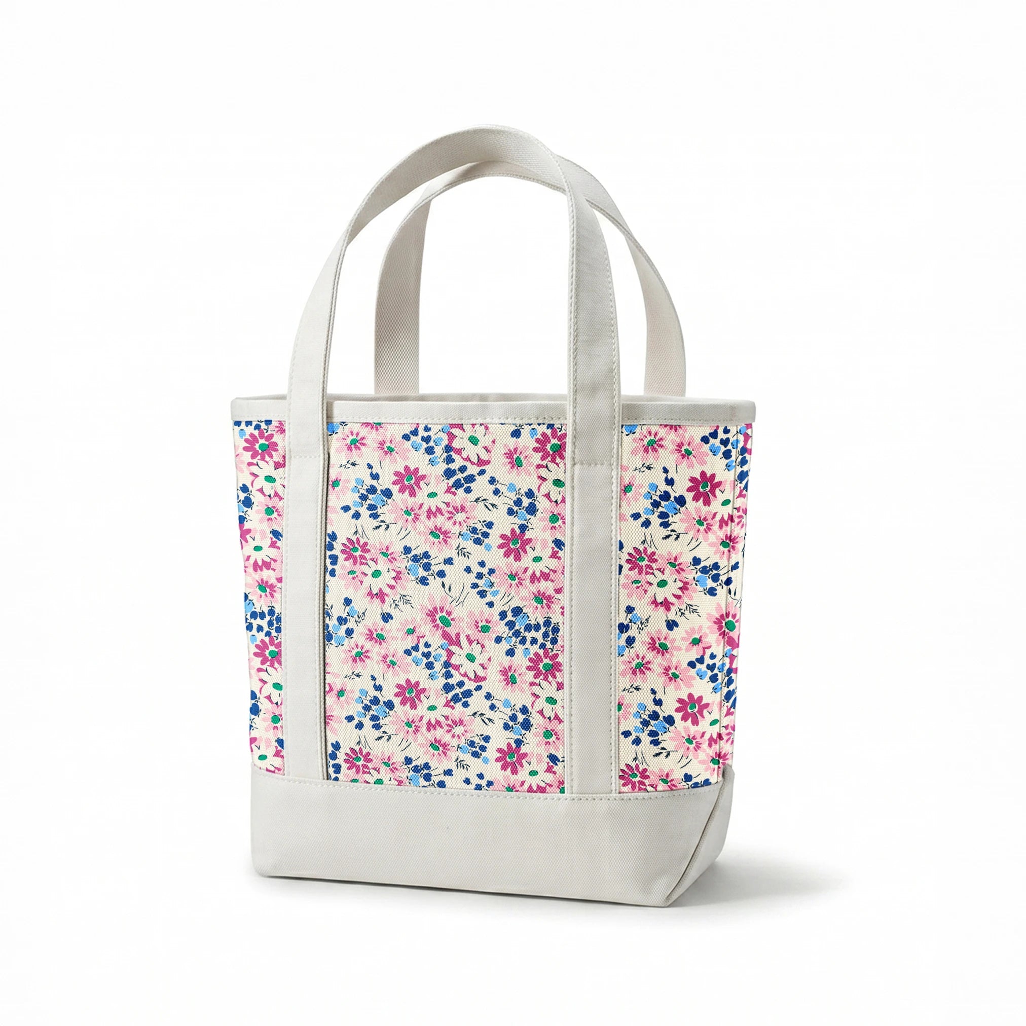 Colorful floral pattern with pink and magenta daisies, blue berries, and green accents on cream background springs canvastote mockup