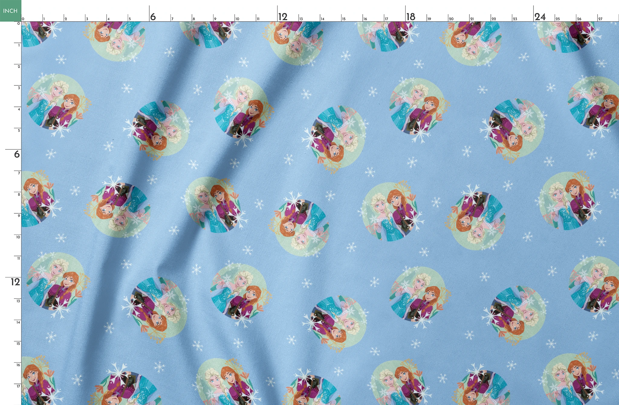 Light blue background with repeating circular motifs of "Frozen" characters and snowflakes in a decorative pattern springs fatquarter mockup