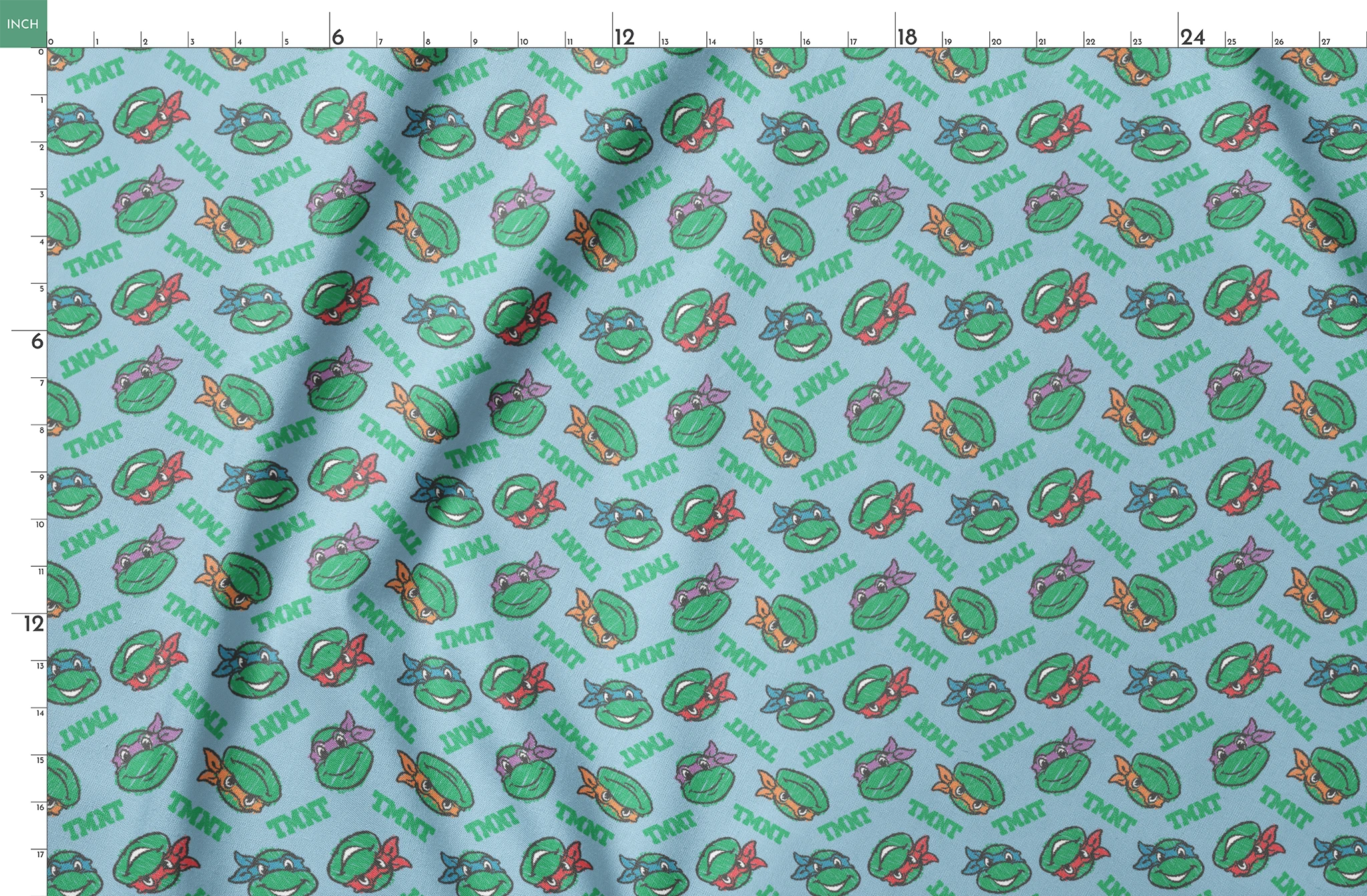 Cartoon pattern of Teenage Mutant Ninja Turtles faces with colored masks on light blue background springs fatquarter mockup