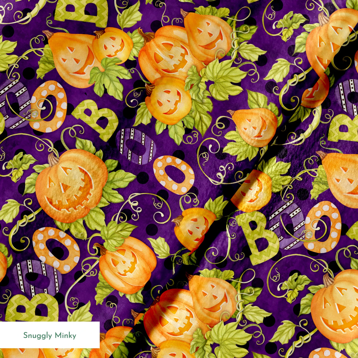 Halloween fabric by Nicole Tamarin with smiling jack-o’-lanterns, “BOO” text, vines, and leaves on a purple background. springs minky texture