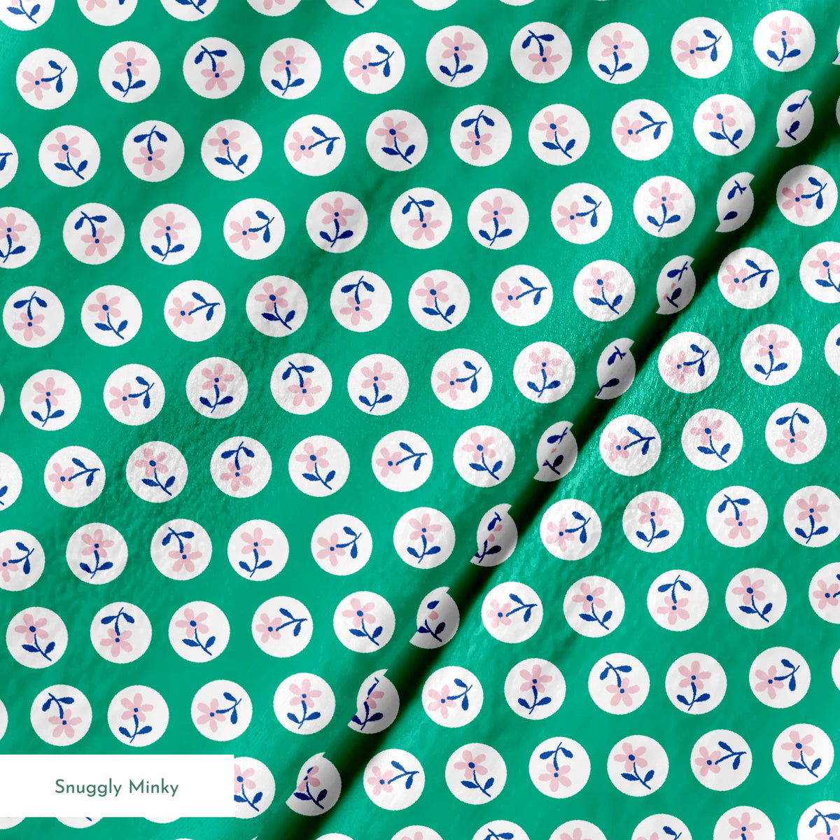 Pink flower motifs with blue stems on white circles against a green background springs minky texture
