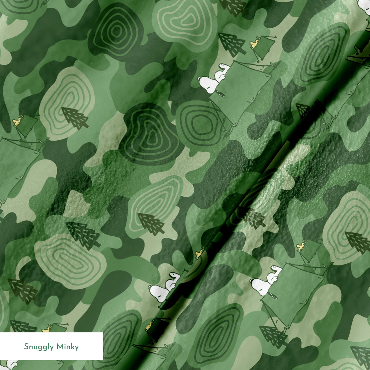 Snoopy camping scene with tents and trees on a green camouflage pattern background springs minky texture