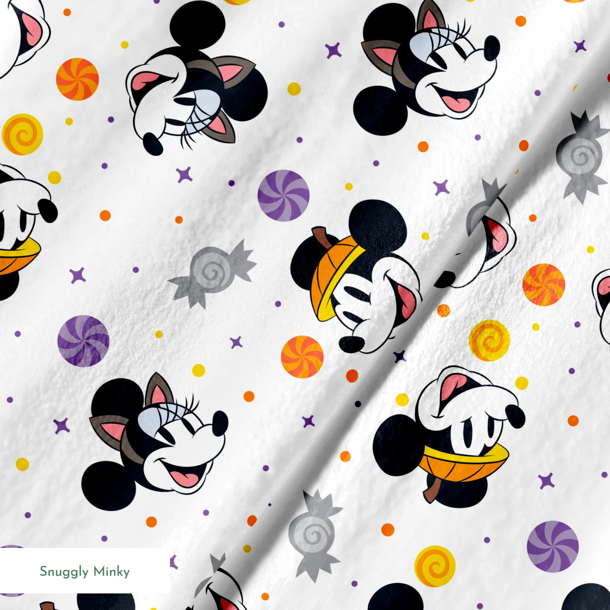 Mickey and Minnie Mouse cartoon heads scattered with wrapped candies and colorful dots on white background springs minky texture
